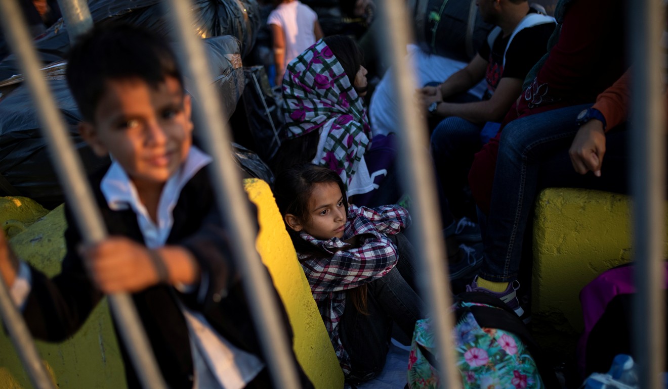 Children from Afghanistan wait to board a catamaran that will transfer them to the mainland from Lesbos. Photo: Reuters