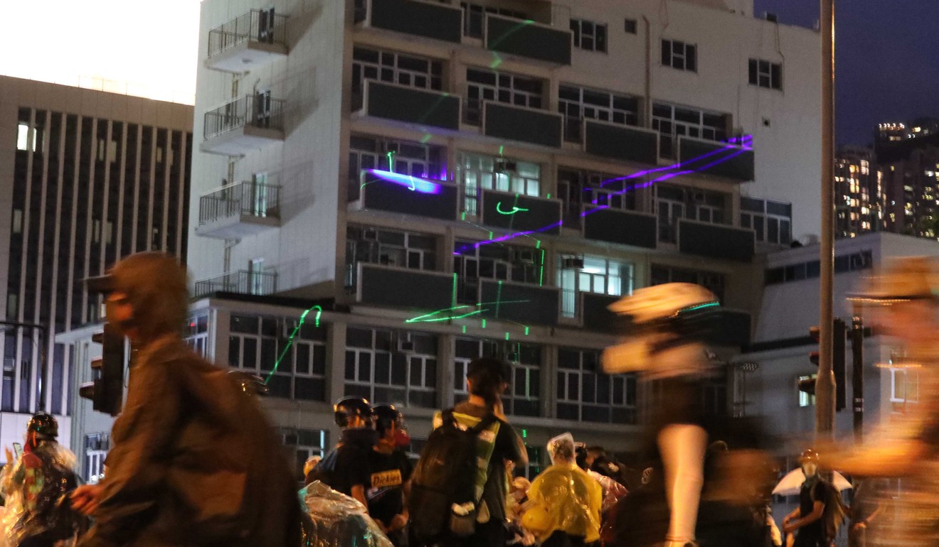 Protesters point lasers on buildings. Photo:Felix Wong