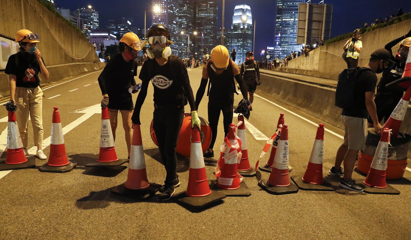 Black-shirted protesters barricade a tunnel in Admiralty on Tuesday. Photo: EPA