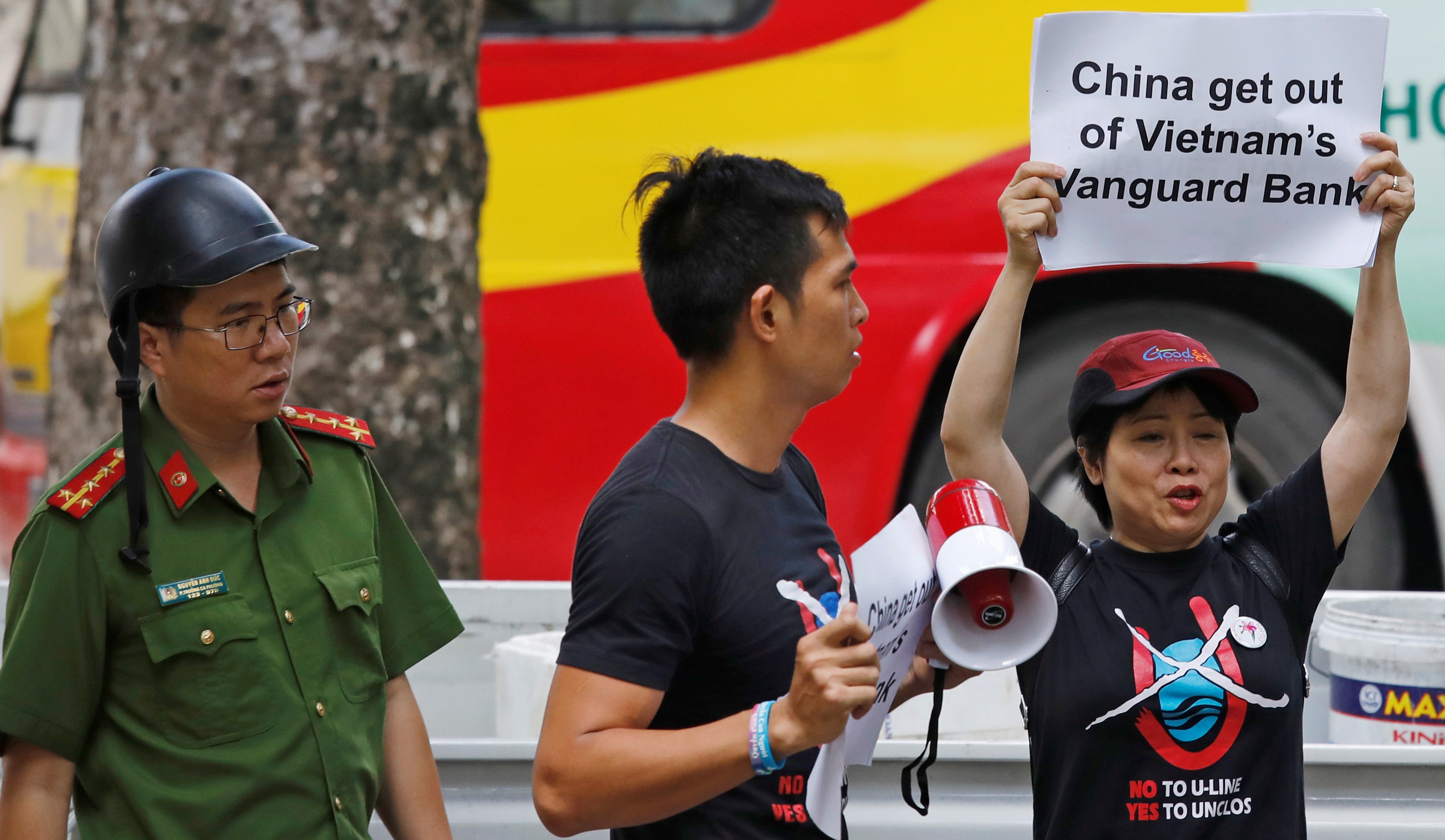 A Vietnamese policeman (left) approaches anti-China protesters in front of the Chinese embassy in Hanoi on August 6. Photo: Reuters