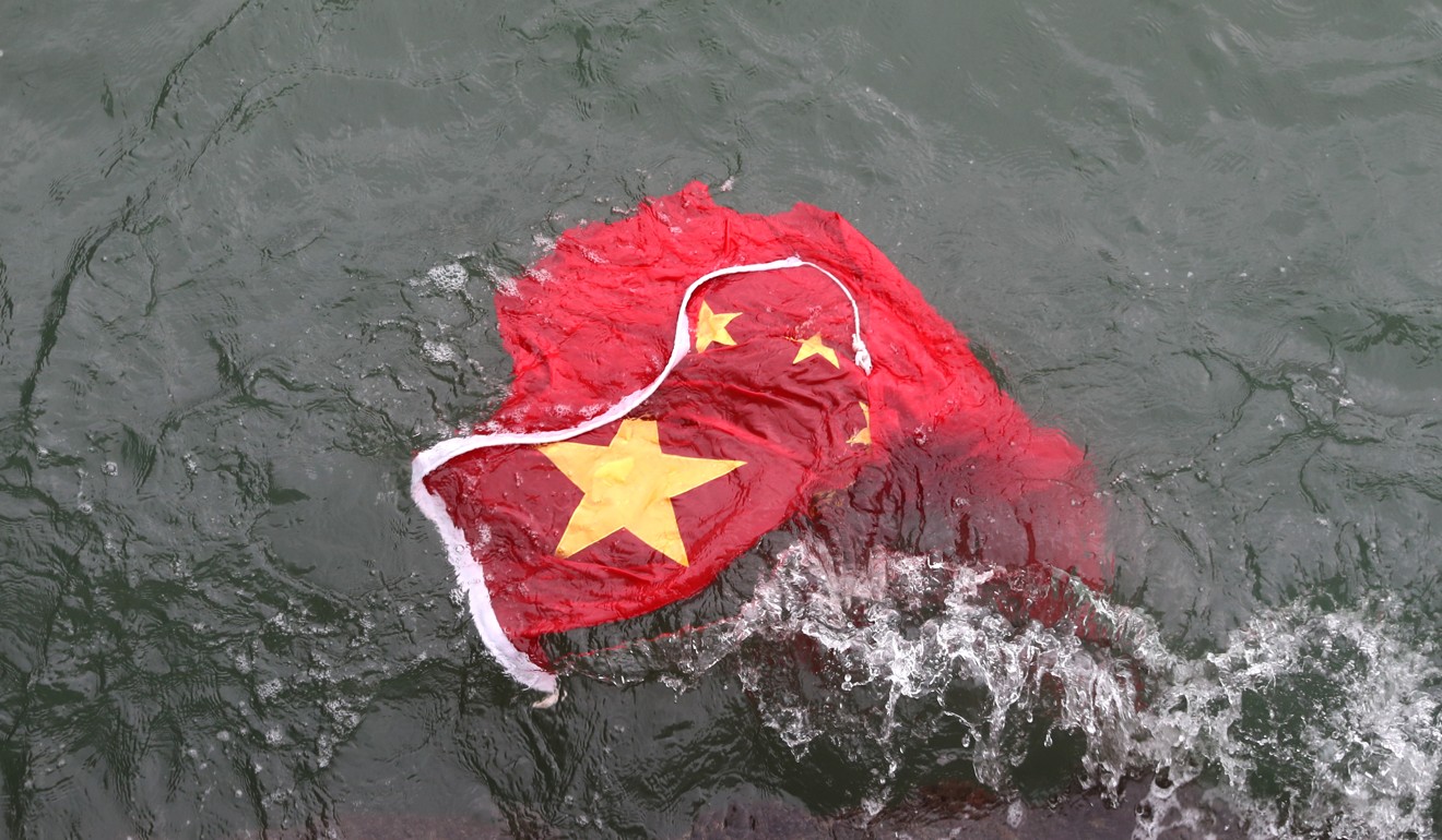 The Chinese national flag floats in Victoria Harbour off Tsim Sha Tsui, after being taken off a pole outside a shopping centre and thrown into the water by protesters on August 3. Photo: Sam Tsang