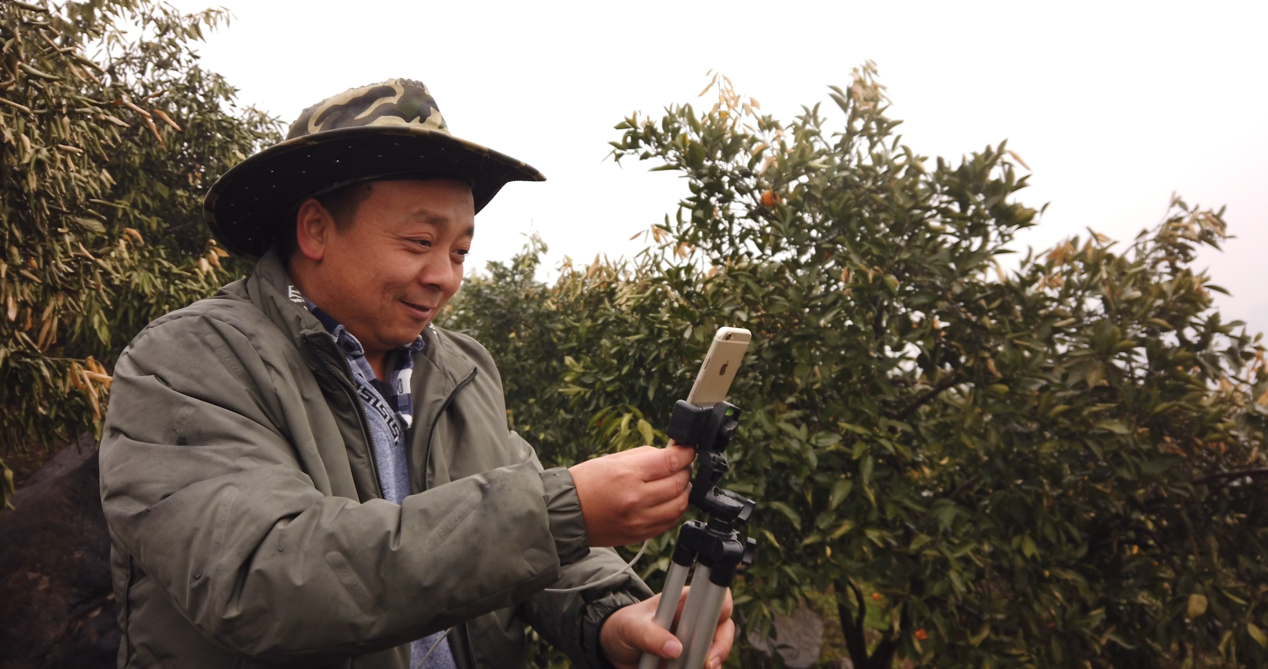 Zhong Haihui, a fruit farmer from central China's Hunan province, uses an iPhone 6, a small tripod and a power bank when live-streaming video for short video app operator Kuaishou and e-commerce platform Taobao Marketplace. Photo: Chris Chang
