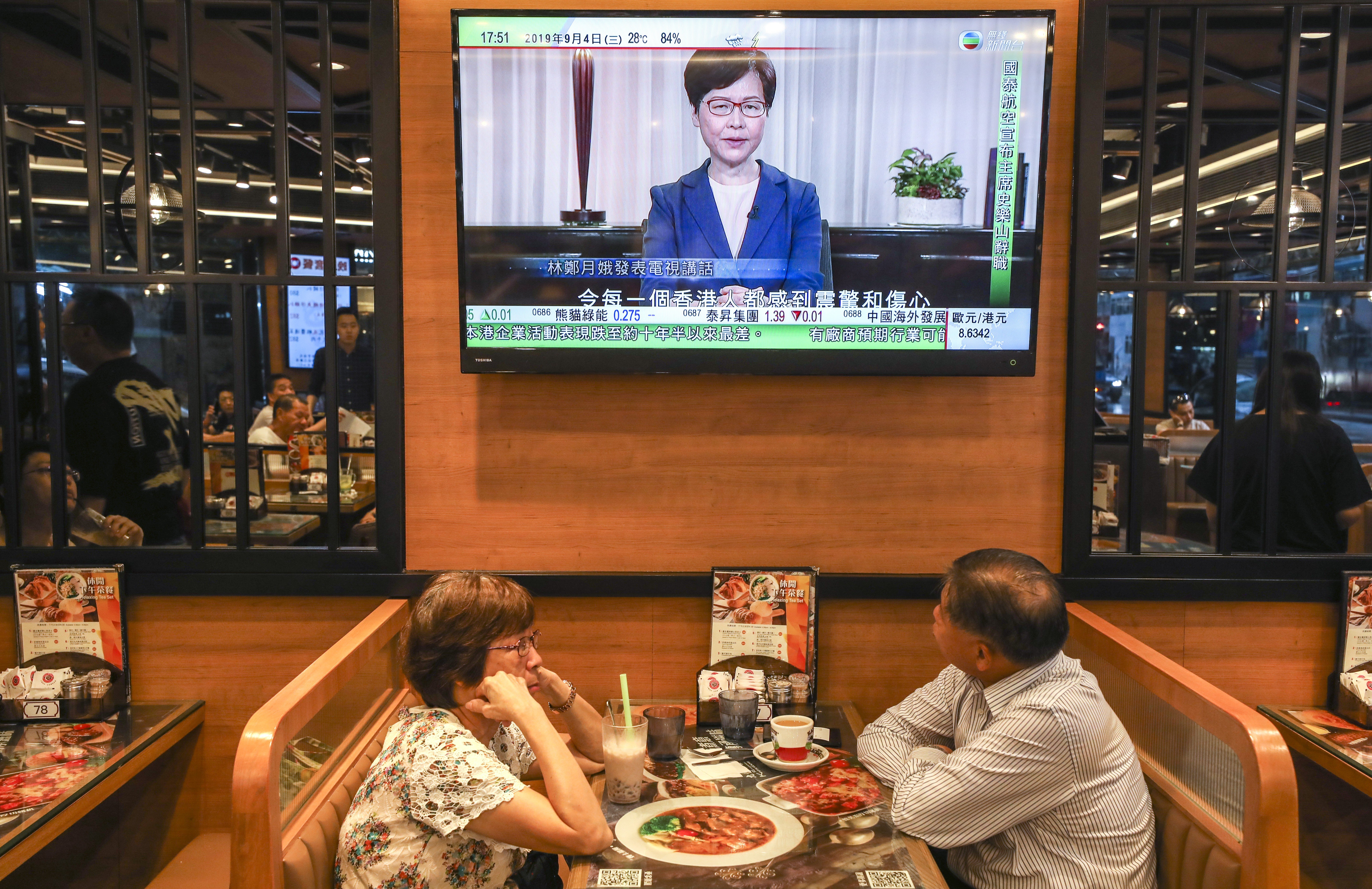 Diners listen as TV stations play a pre-recorded message from Chief Executive Carrie Lam announcing the withdrawal of the extradition bill, on September 4. Photo: Robert Ng