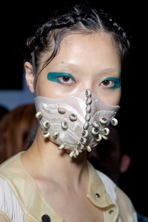 Chinese designer Masha Ma has joined models, musicians and social media influencers in launching versions of the face mask. She embedded her SS15 collection with Swarovski crystals and presented them at Paris Fashion Week.