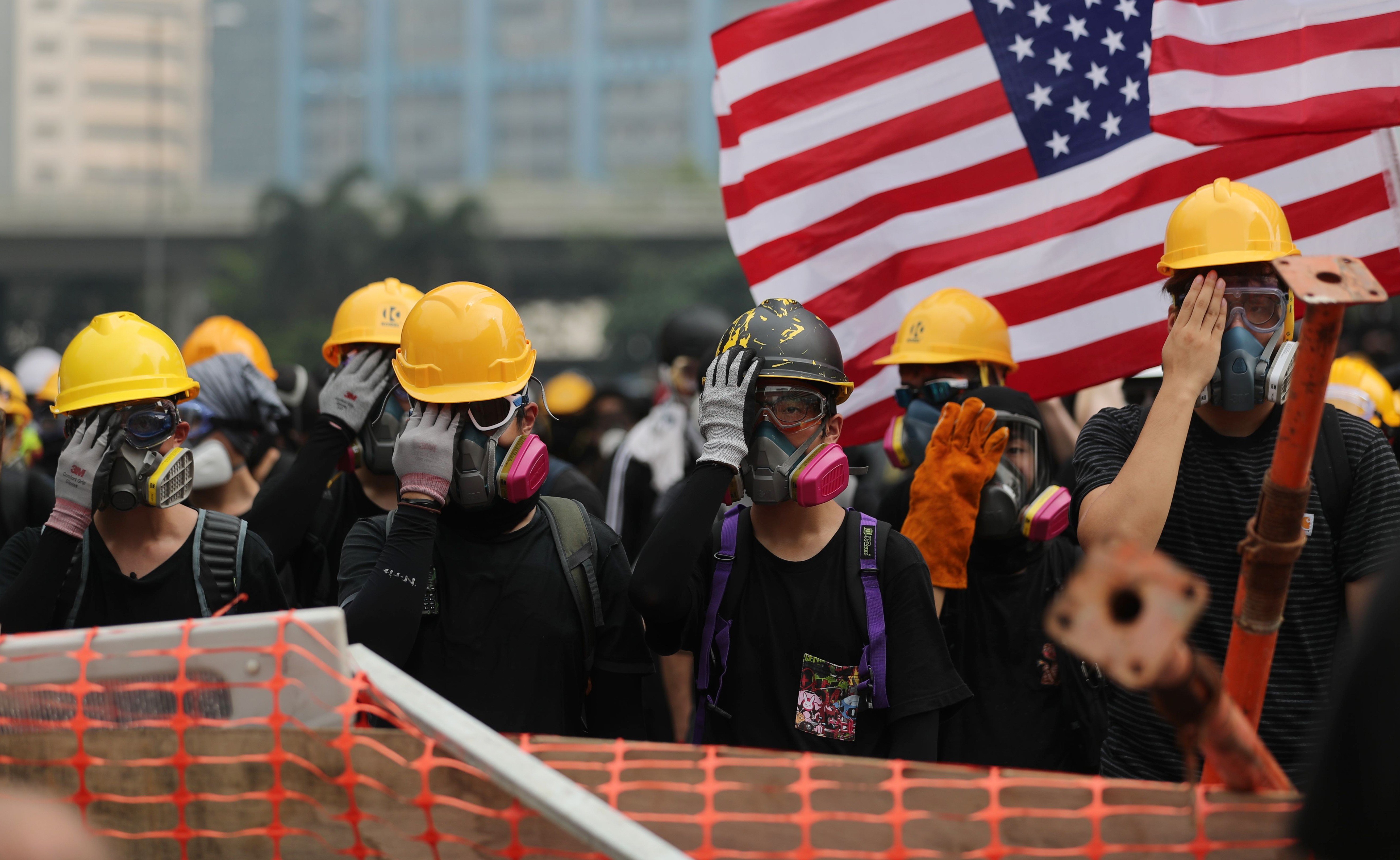 The US flag is waved as anti-government protesters on August 24 cover their right eye in tribute to the protester who suffered a severe eye injury during a demonstration. The US guarantees freedom of expression under the First Amendment but this freedom is based on the premise of peaceful assembly. Photo: Sam Tsang