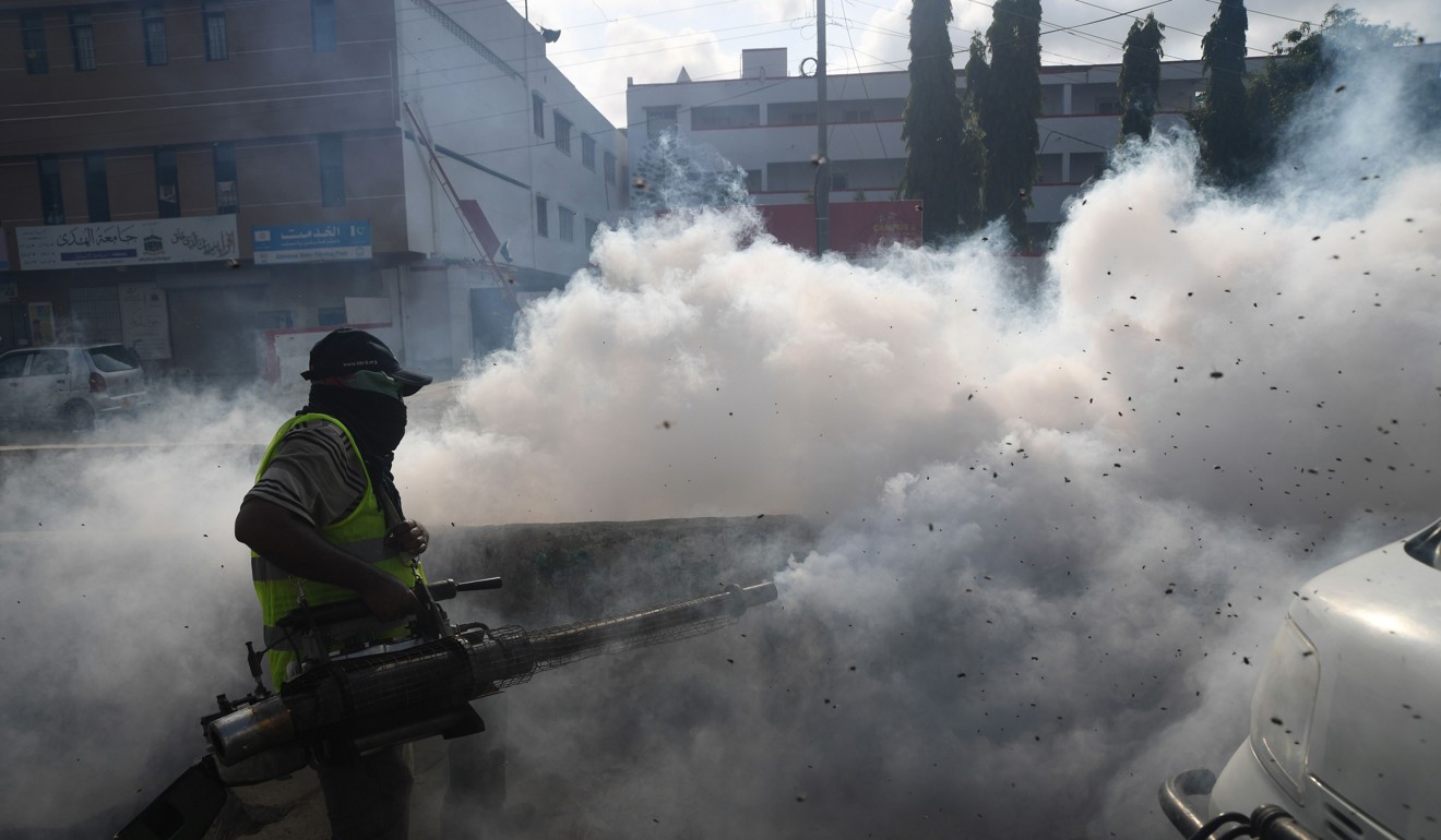 A municipal worker fumigates against flies and mosquitoes on a street in Karachi. Photo: AFP