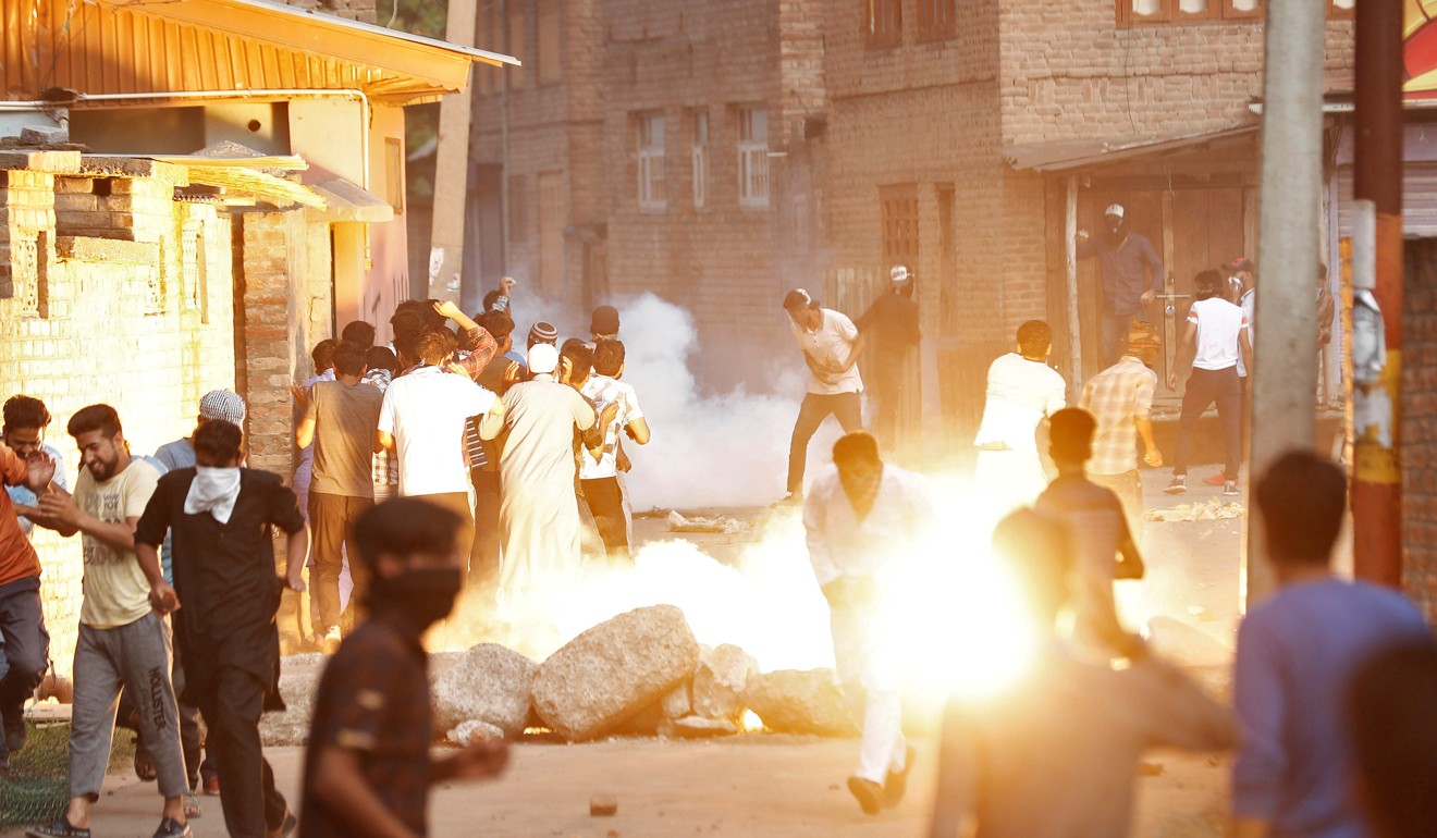 Kashmiris run for cover as a tear gas shell fired by Indian security forces explodes on August 23. Photo: Reuters