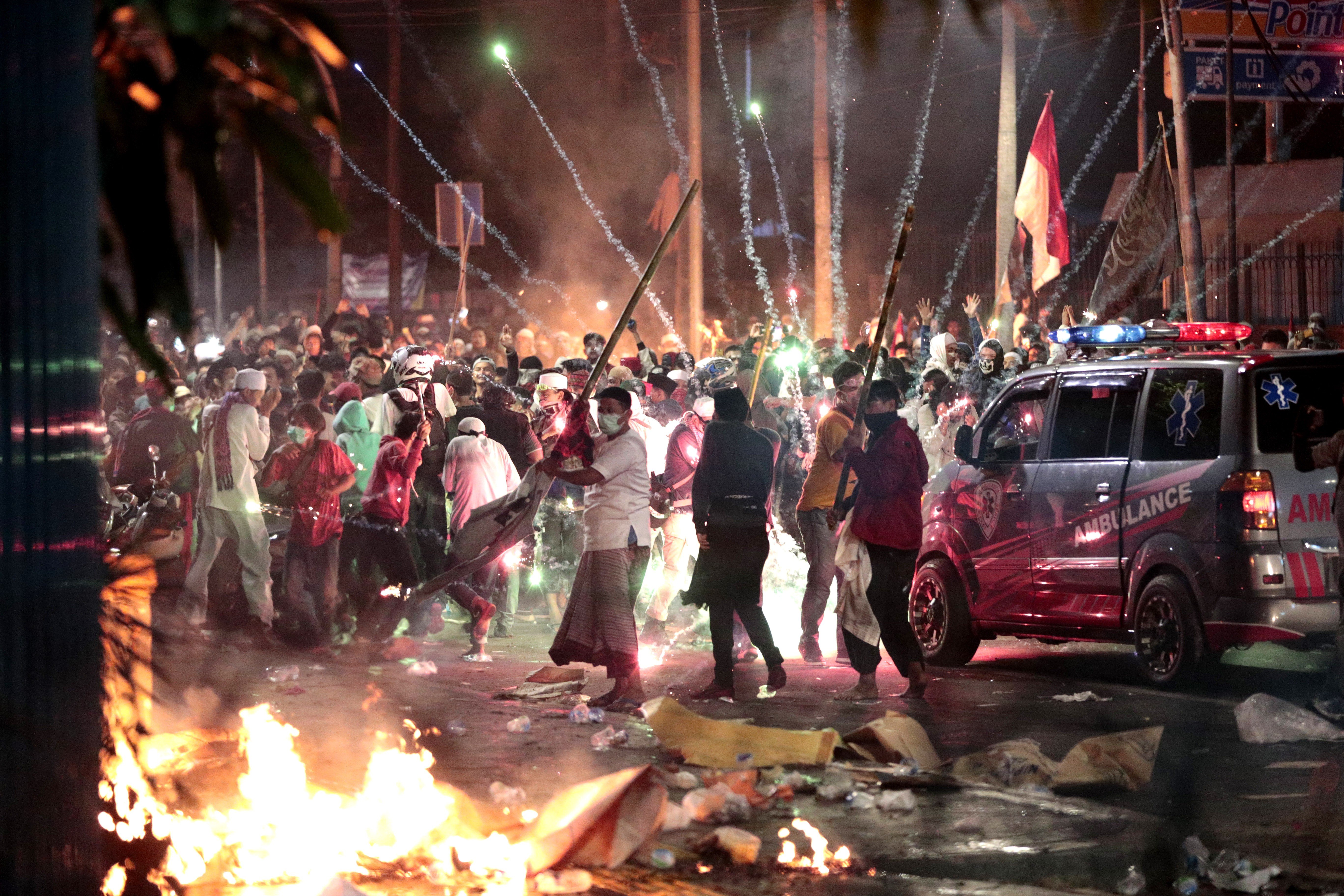 Firecrackers explode near protesters during clashes with police in Jakarta in May. Photo: AP