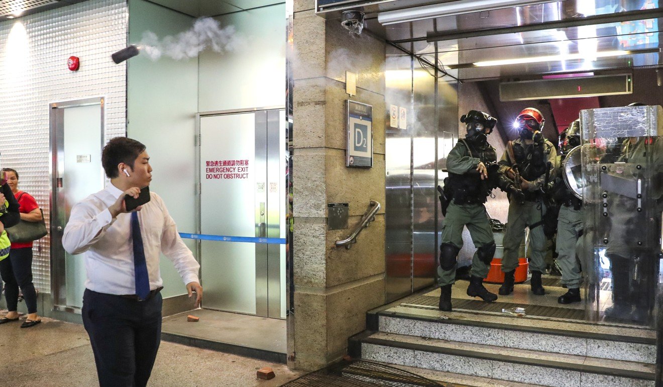 A tear gas canister lobbed from an MTR exit in Causeway Bay sails over the head of a passer-by. Photo: Sam Tsang