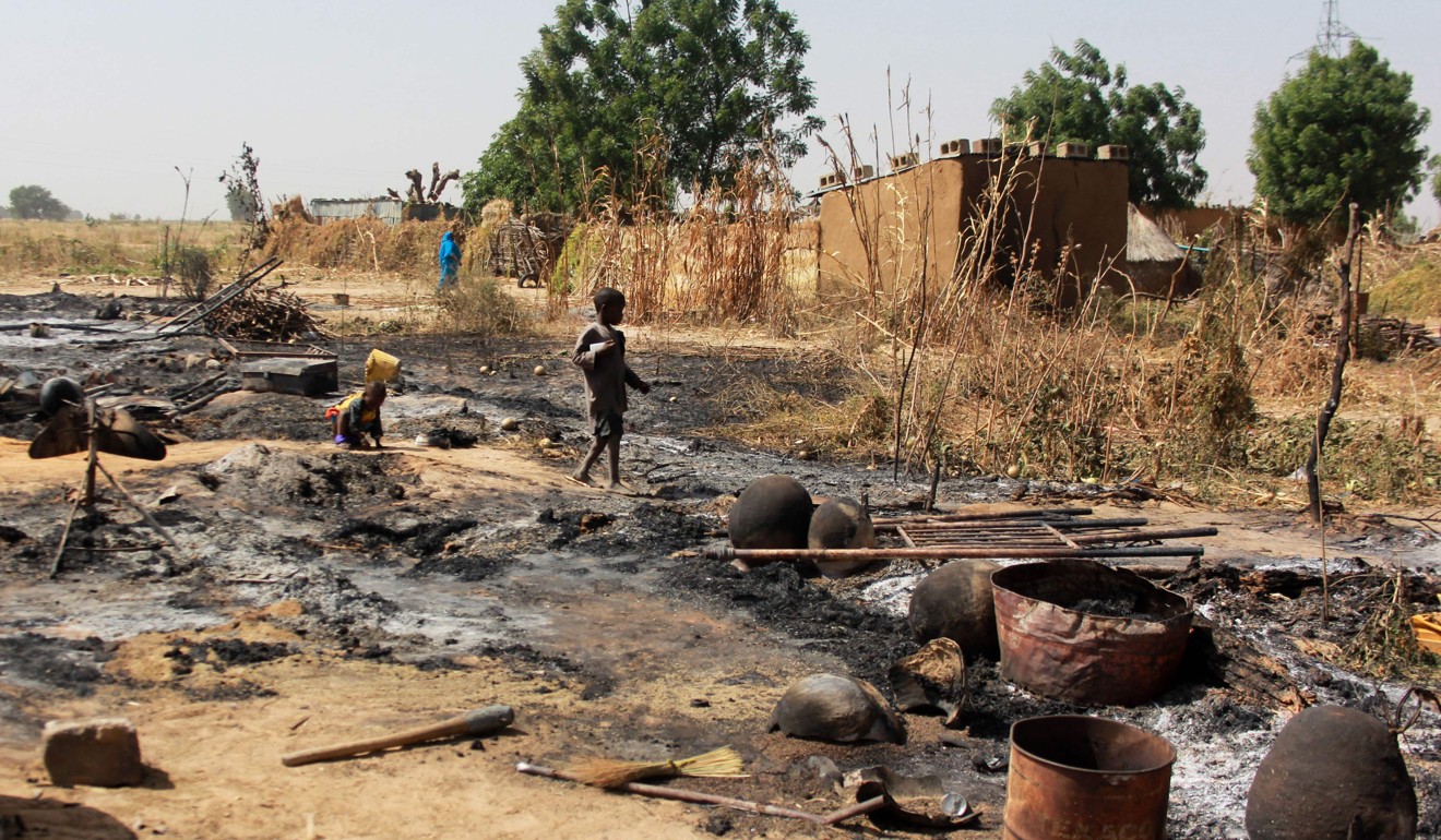 A boy walks past the remains of a village burnt down by Boko Haram on the outskirts of Maiduguri in December. Photo: AFP