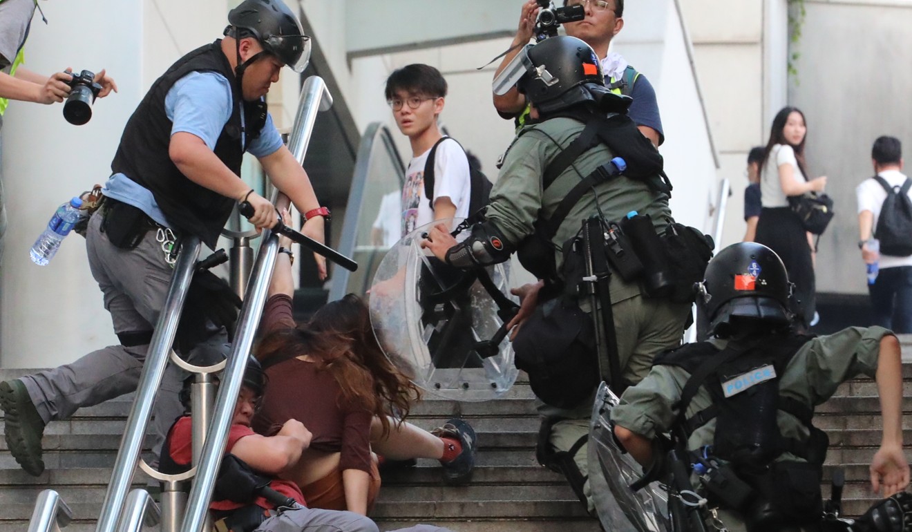 Riot police arrest a woman outside a shopping mall in Tung Chung on Saturday. Photo: Felix Wong