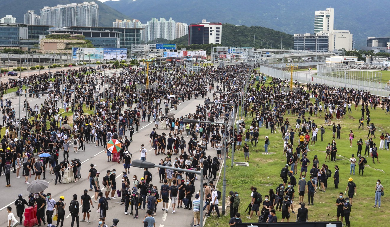Travellers and airline crew were forced to get off their buses and make their way to the airport on foot as protesters crippled airport services on September 1. Photo: Felix Wong