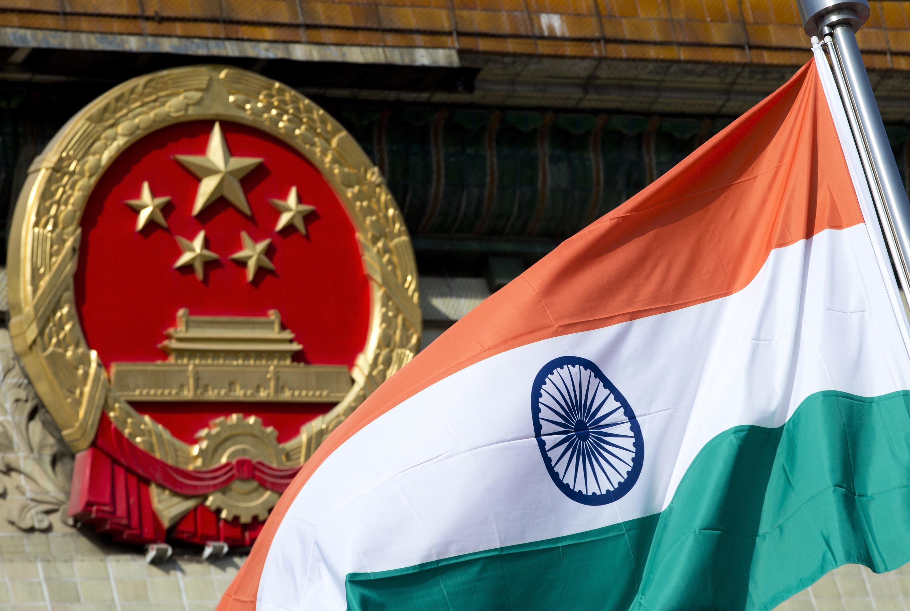 The Indian national flag is flown next to the Chinese national emblem in Beijing. Photo: AP