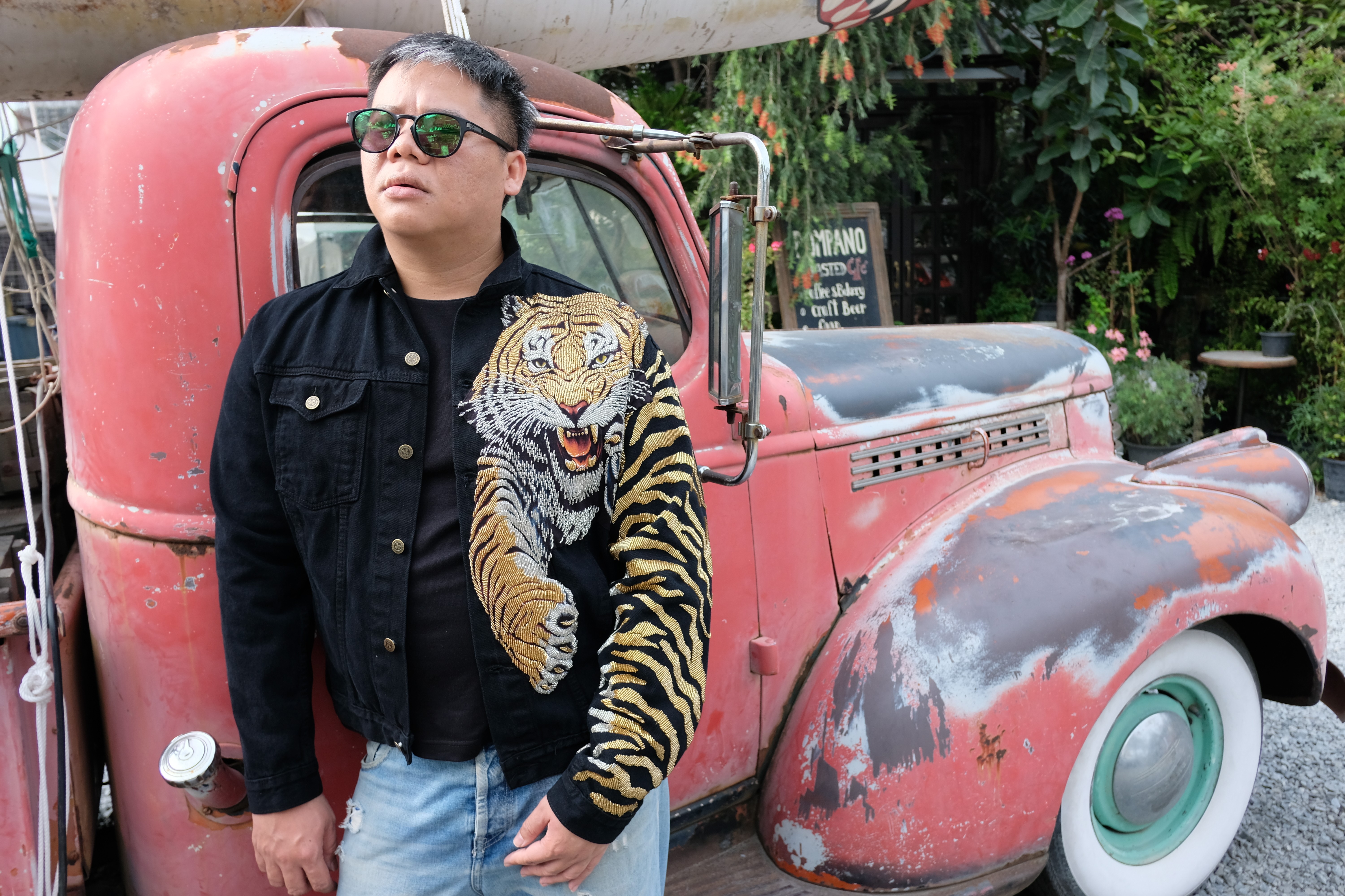 Thai fashion designer Santichai Srisongkram wears his label’s “Thaiger-Man” jacket at a retro outdoor market in Bangkok, Thailand. He has had orders for customised versions of the jacket from as far away as Colombia. Photo: Photo: Tibor Krausz