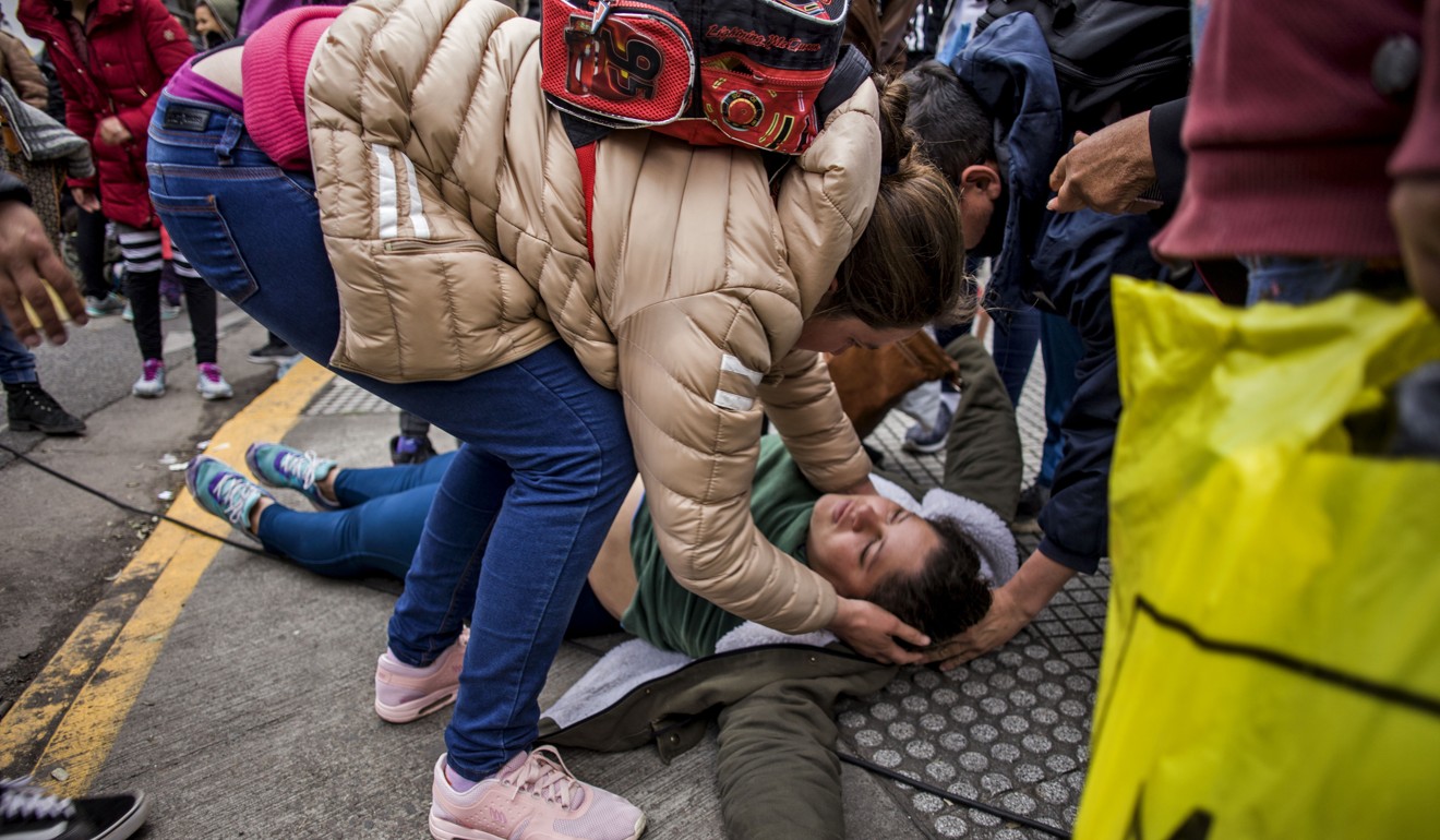 An injured protester lies on the ground after clashes with riot police in Buenos Aires. Photo: DPA