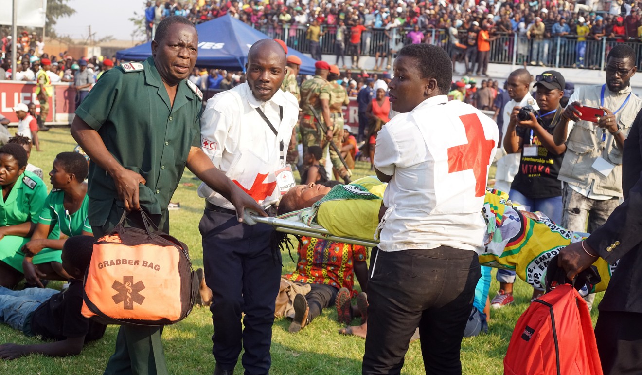 Members of the Red Cross carry an injured woman after a stampede to see the body of former Zimbabwean President Robert Mugabe at Rufaro Stadium in Harare on Thursday. Photo: EPA-EFE