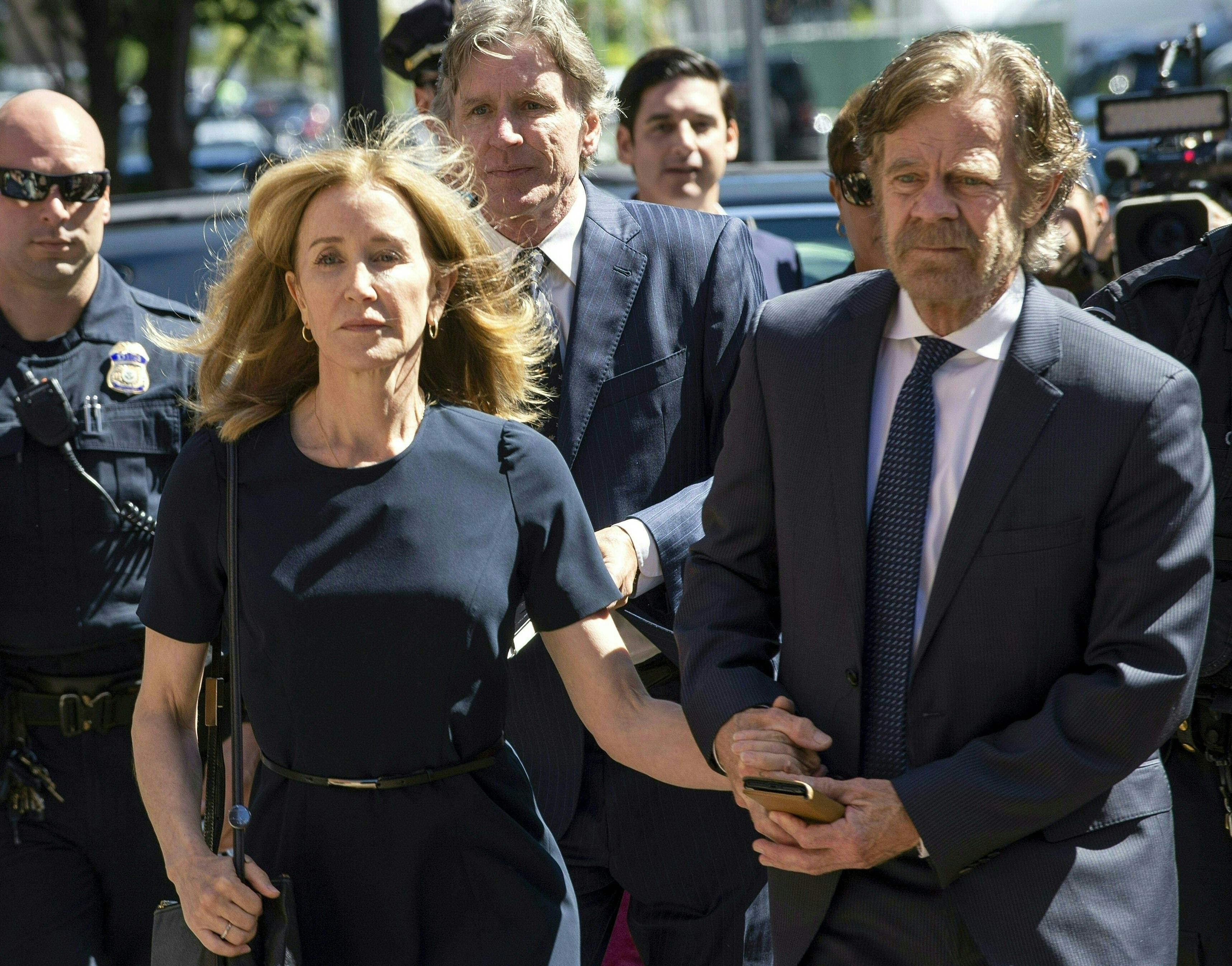 Actress Felicity Huffman, escorted by husband William H. Macy, makes her way to the courthouse entrance in Boston on Friday. Photo: AFP