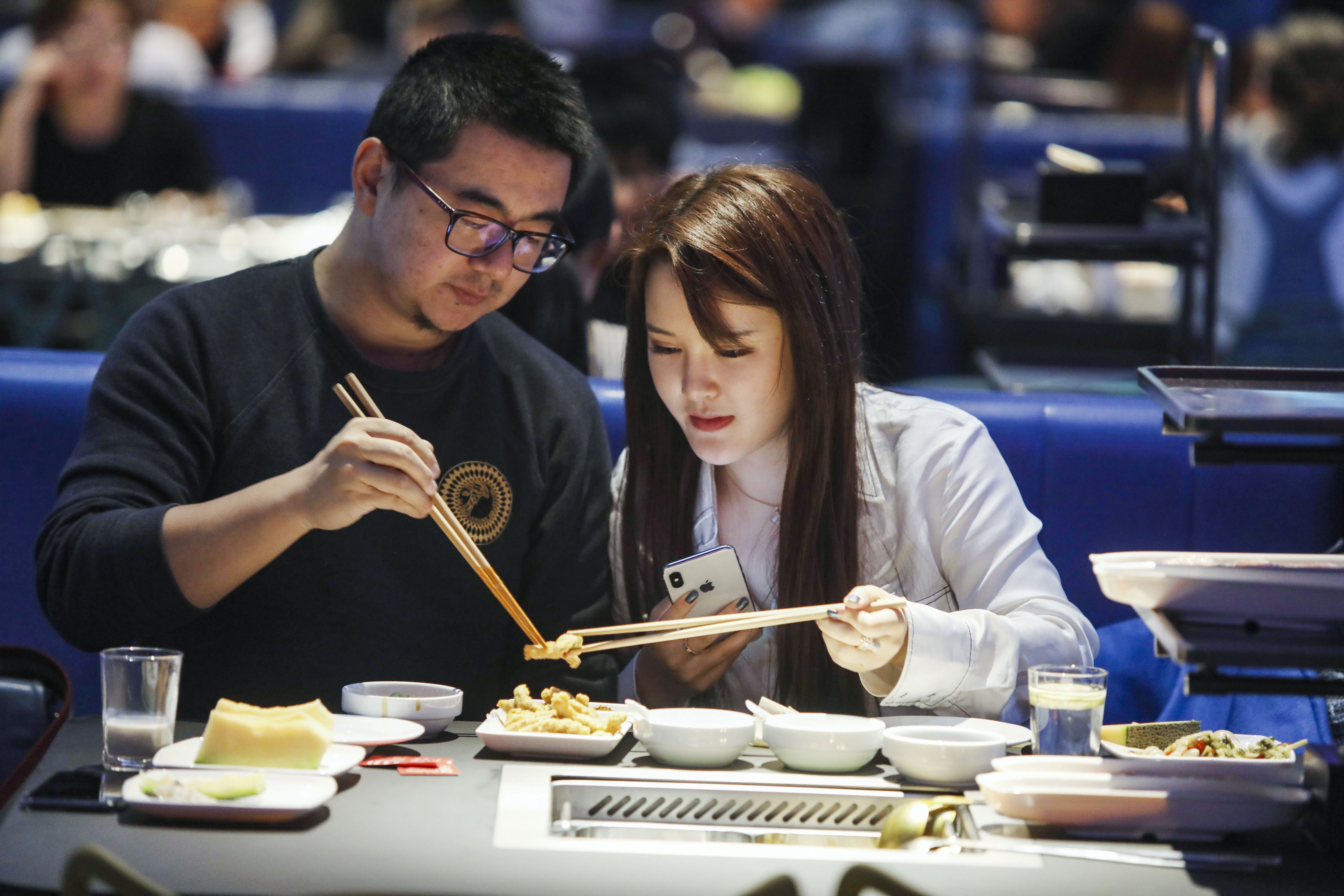 A young couple enjoying a meal at a Haidilao hotpot restaurant in Beijing. Photo: Simon Song