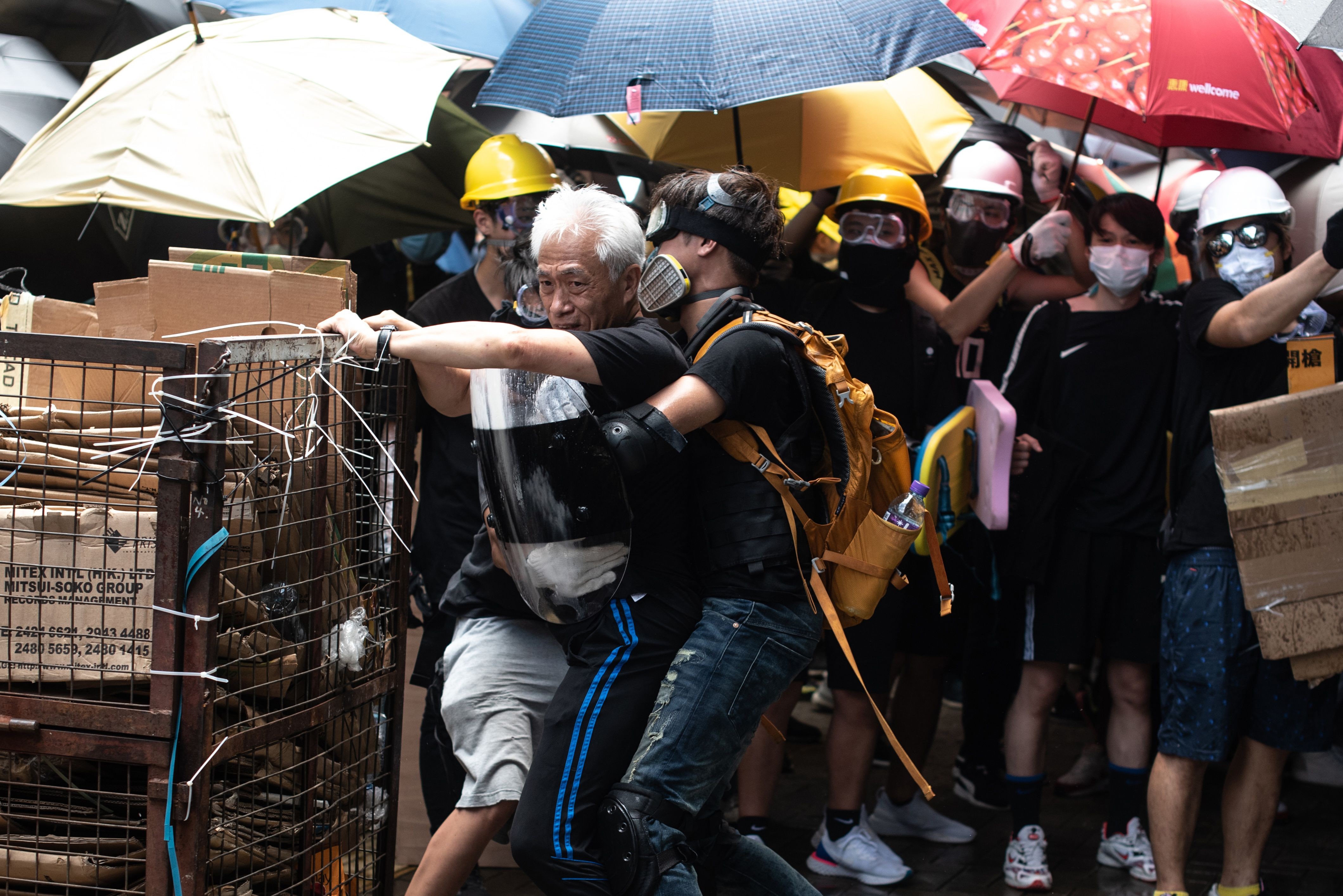 Pro-democracy lawmaker Leung Yiu-chung is restrained by protesters as he tries to stop them from breaking into the Legislative Council on July 1. Photo: AFP