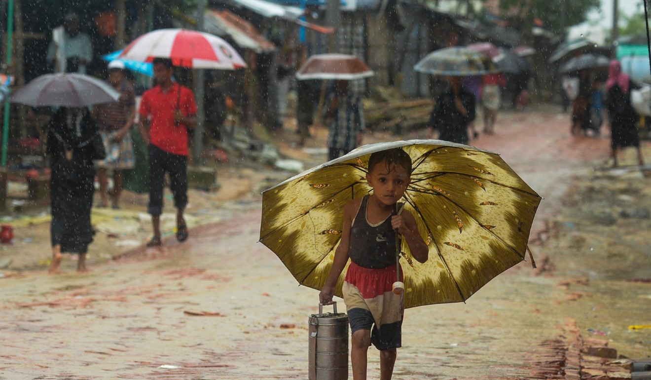 A Rohingya refugee boy shelters under an umbrella at Kutupalong refugee camp in Bangladesh. Photo: AFP