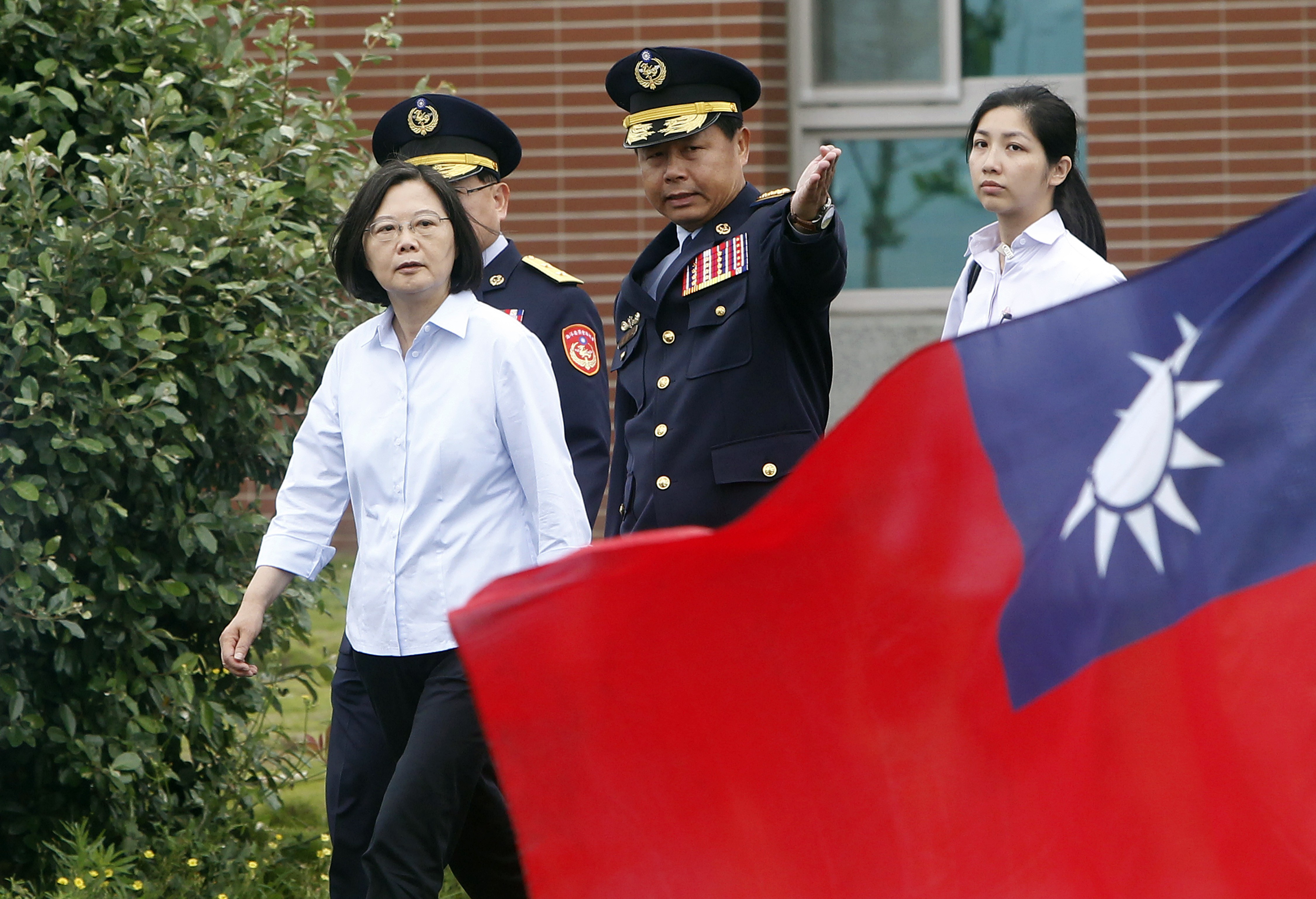 Taiwanese President Tsai Ing-wen, left, walks past a Taiwan national flag during an offshore anti-terrorism drill outside Taipei harbor in New Taipei City, on August 15. Tsai has been vocal in her support of the demonstrations in Hong Kong against China’s deepening encroachment. Photo: AP