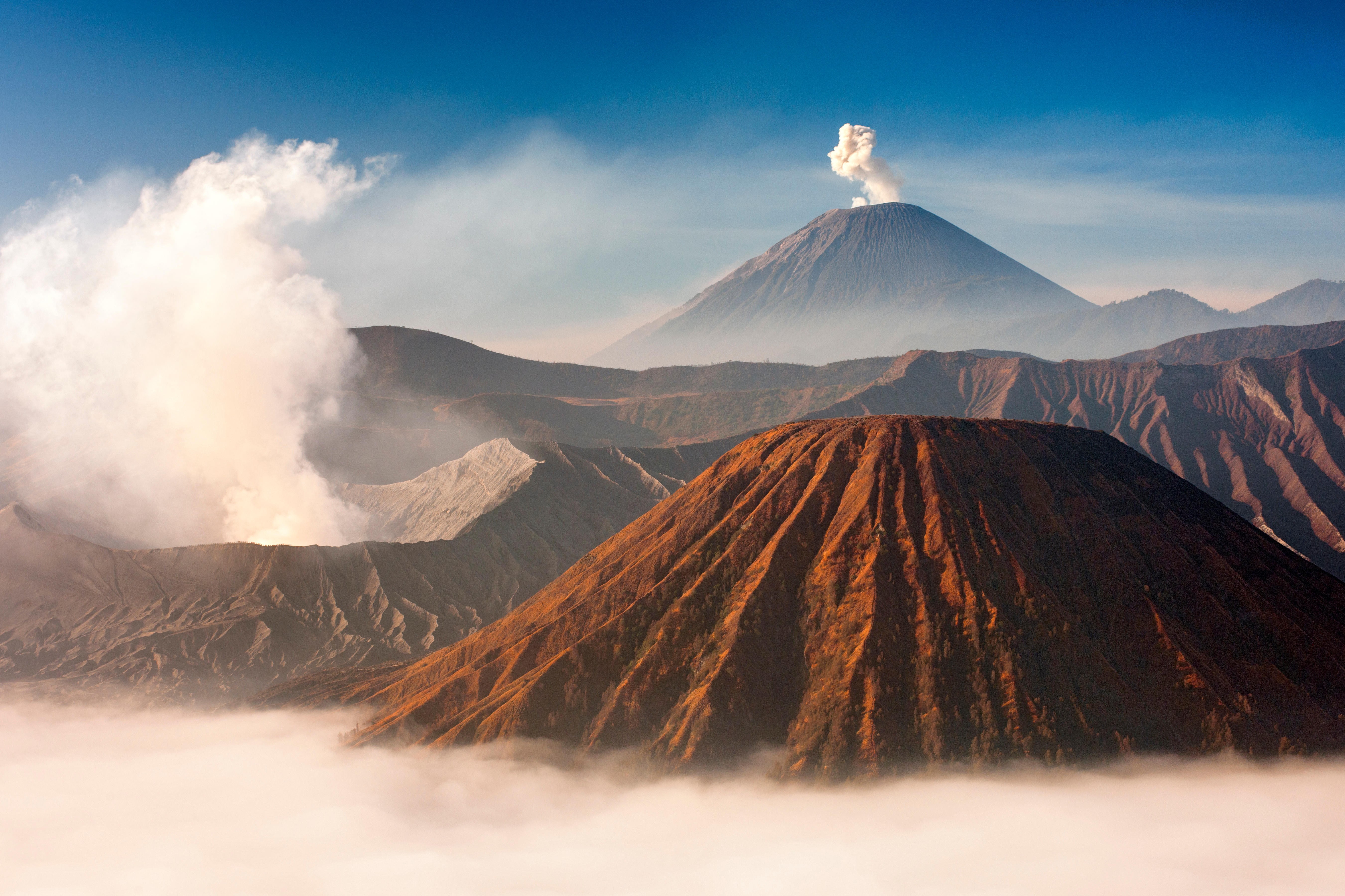 Mount Bromo (venting steam, left) and Gunung Semeru (centre, background) in Bromo Tengger Semeru National Park, Java, Indonesia. Photo: Alamy