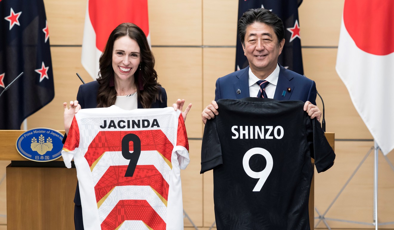 New Zealand PM Jacinda Ardern and Japan PM Shinzo Abe hold jerseys bearing their names after a joint press conference in Tokyo. Photo: Getty Images