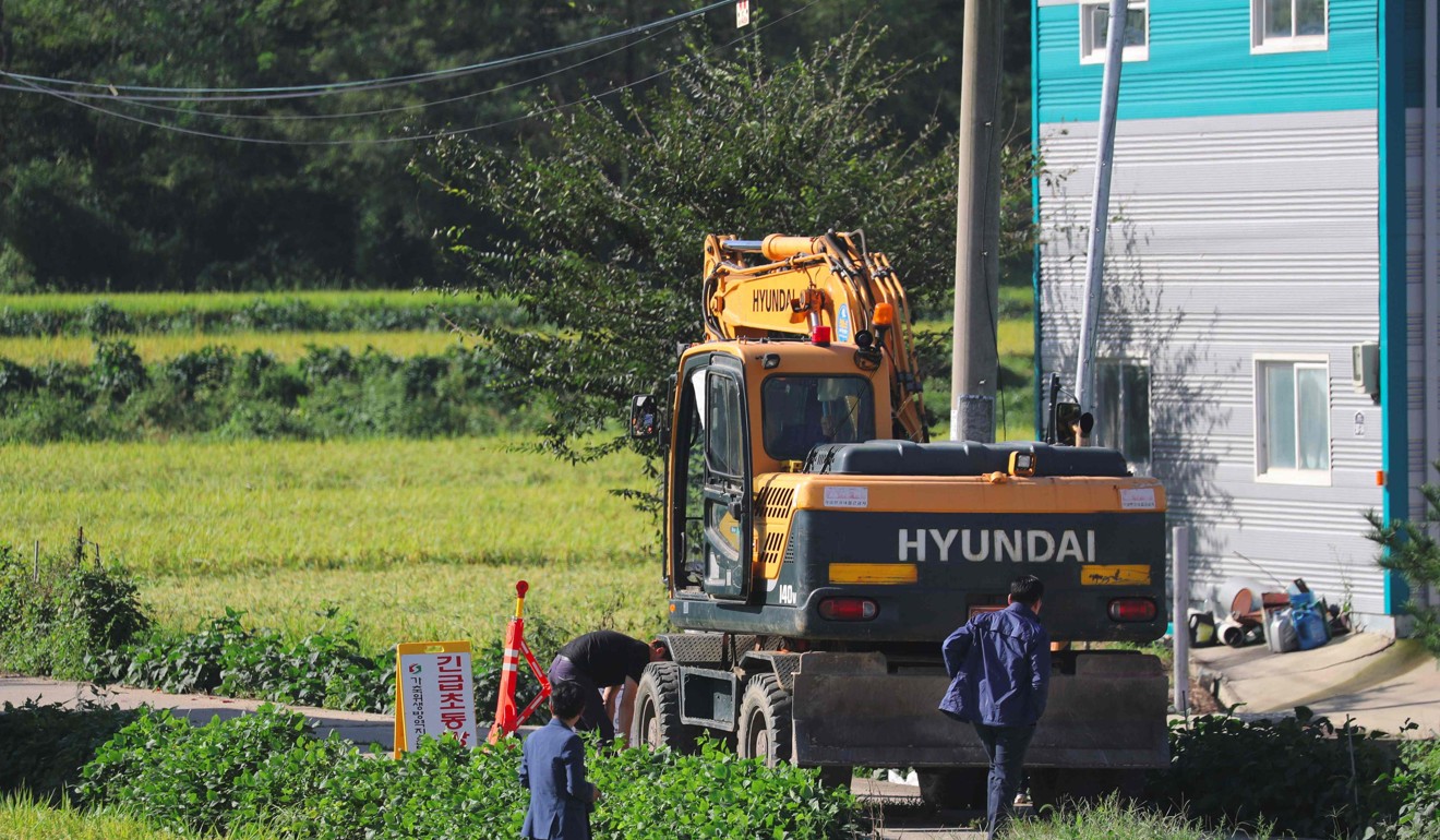 An excavator is seen in front of a barricade in an area where pigs were confirmed to have been infected with African swine fever in Paju. Photo: AFP