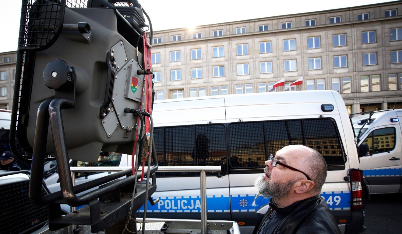A protester looks at an acoustic crowd dispersal device during a demonstration outside Polandâs ministry of economy building in Warsaw. Photo: Alamy