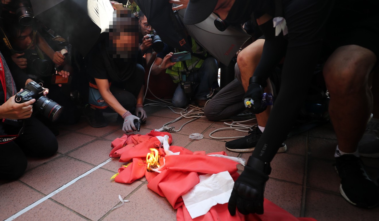 Protesters burn the national flag in Tuen Mun. Photo: Sam Tsang