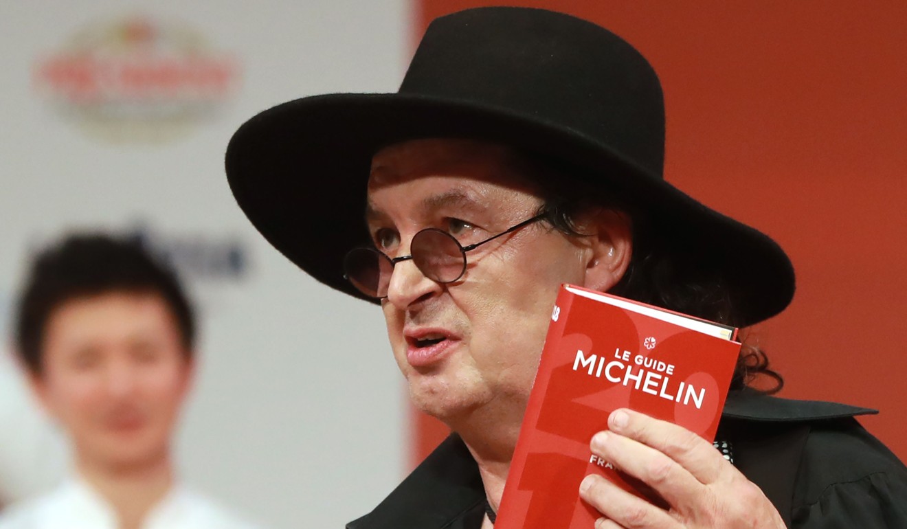 Marc Veyrat holds a Michelin guide after being awarded the maximum three Michelin stars in February last year. Photo: AFP