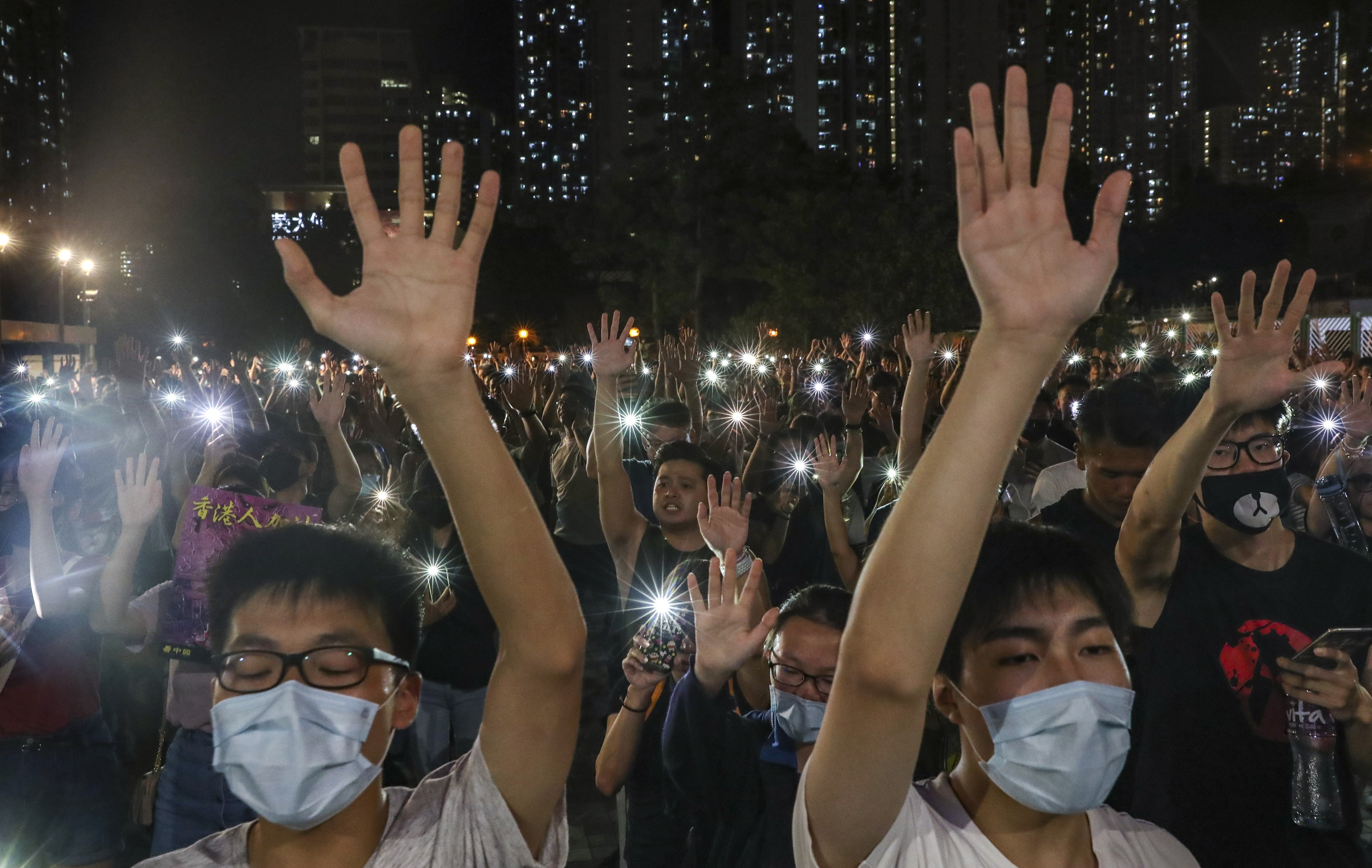 Anti-government protesters hold up their hands to symbolise the “five demands”, as they switch on their mobile phone flashlights and sing “Glory to Hong Kong”, outside an MTR mall in Wong Tai Sin on September 10. Photo: Sam Tsang