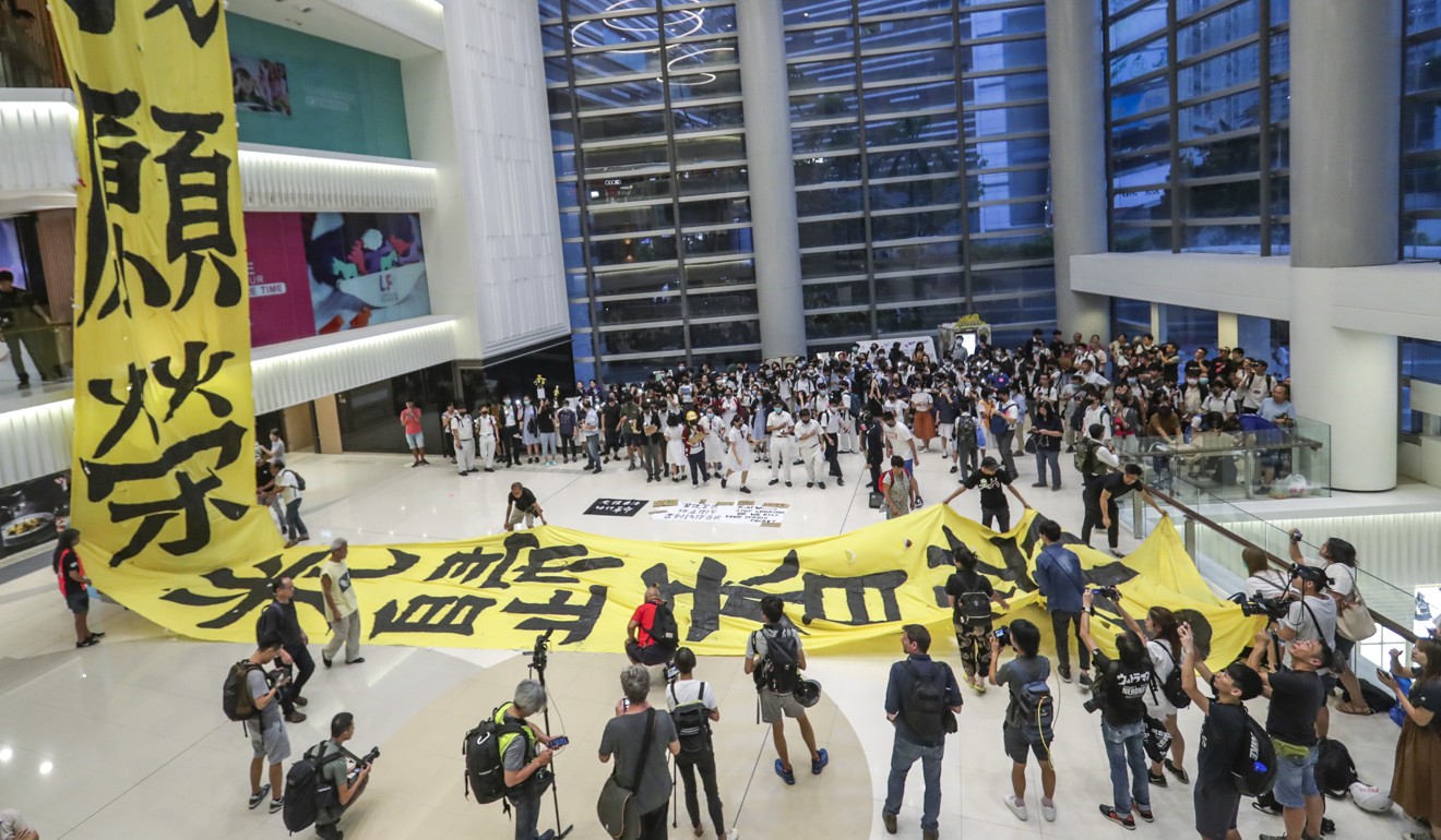 Students and residents from the Lok Fu district in Kowloon take part in a flash mob protest and sing Glory to Hong Kong at Lok Fu Place. They hung a giant banner reading Glory to Hong Kong from a floor of the shopping centre. Photo: Edmond So