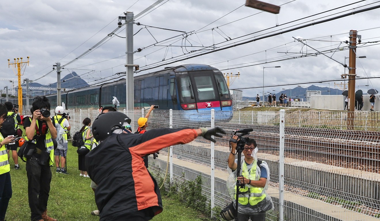 A protester throws a brick on the tracks of the Airport Express train. Photo: Sam Tsang