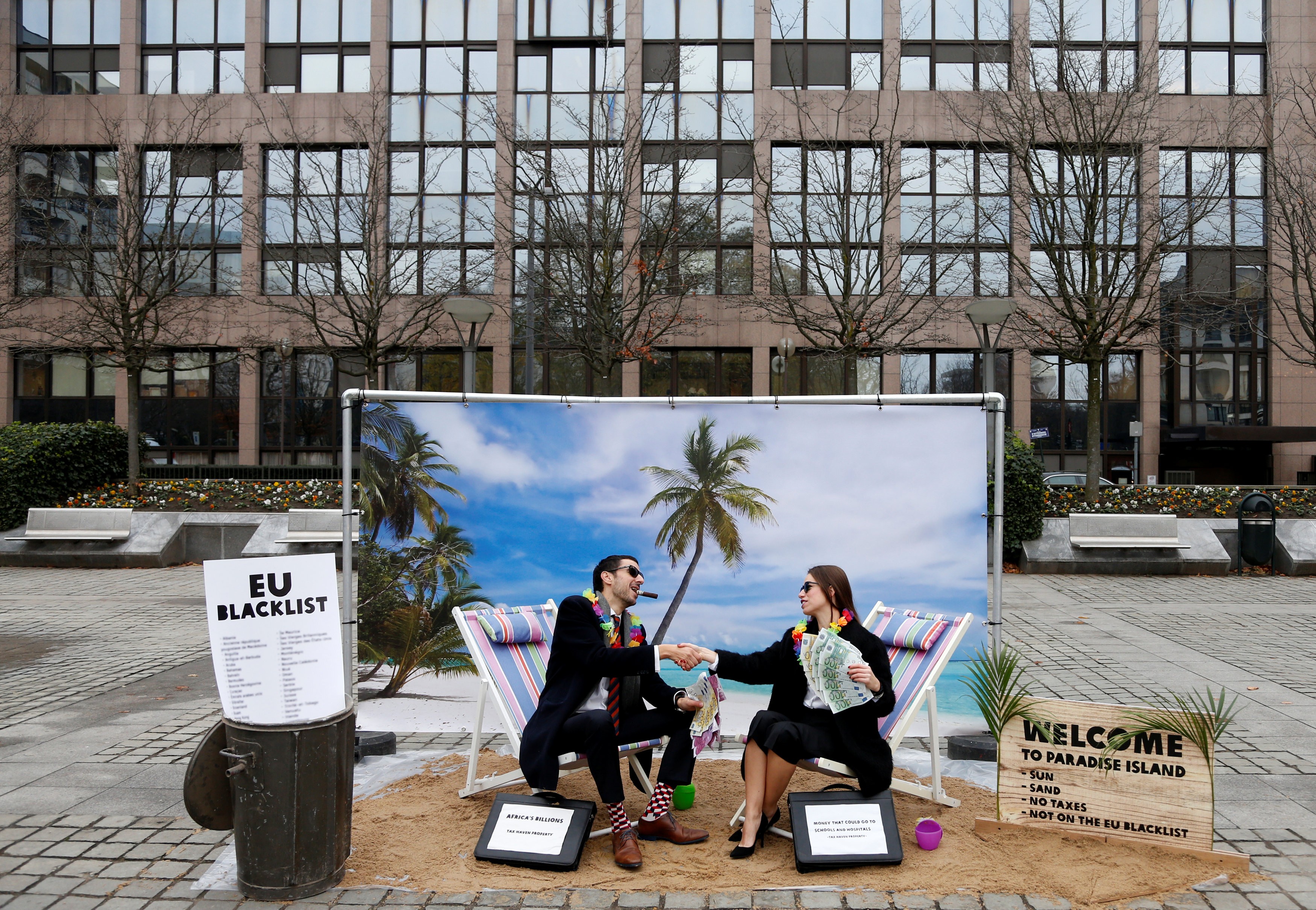 Activists stage a protest against the backdrop of a mock tropical island beach representing a tax haven, outside a meeting of European Union finance ministers in Brussels, Belgium, in December 2017. Improved corporate disclosures include recognising the sustainability impacts and relevance of issues such as tax payments. Photo: Reuters