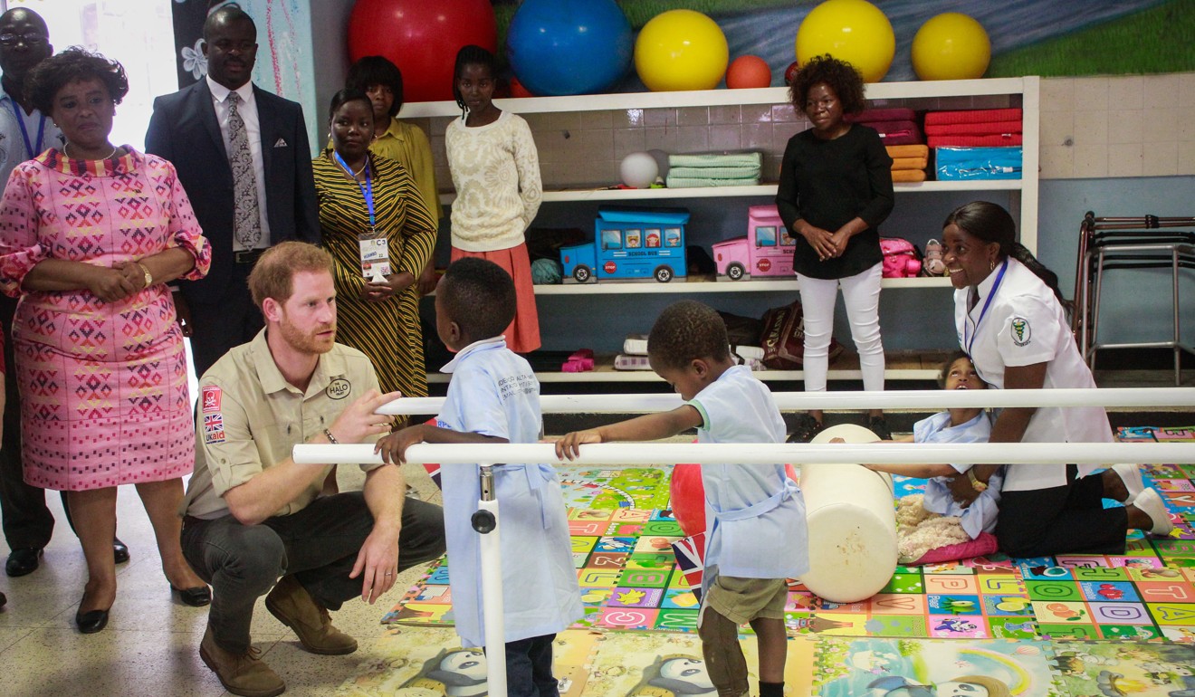 Prince Harry talks with children during a visit to the Centre for Physical Medicine and Rehabilitation, which will be renamed the Princess Diana Centre for Physical Medicine and Rehabilitation, in Huambo, Angola, on Friday. Photo: EPA-EFE
