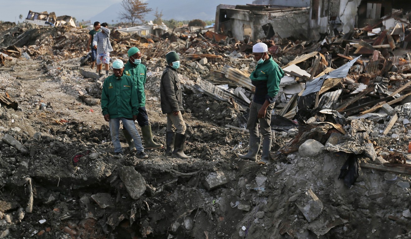 Volunteers examine the damage caused by the earthquake and liquefaction at Balaroa neighbourhood in Palu. Photo: AP