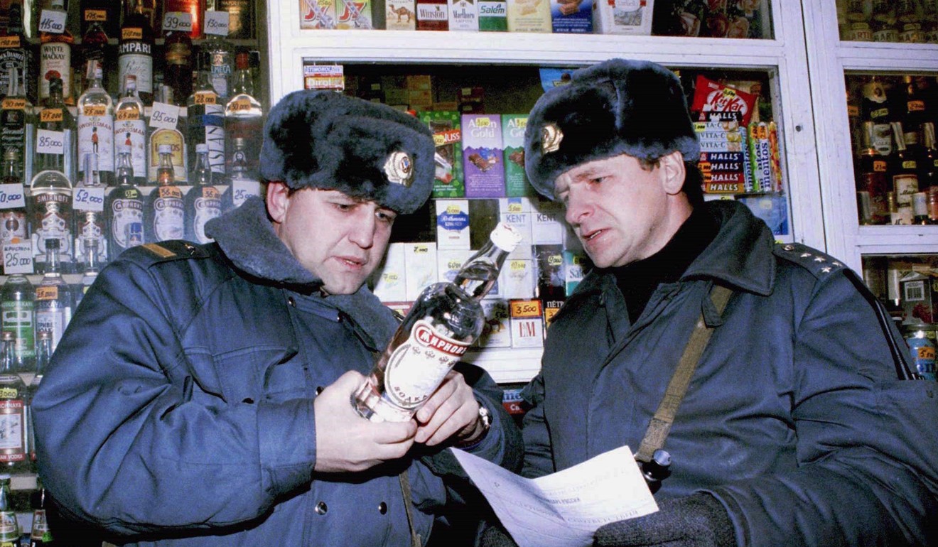 Two policemen examine a bottle of Russian-made vodka during an inspection at a street kiosk in Moscow in 1996. Photo: Reuters