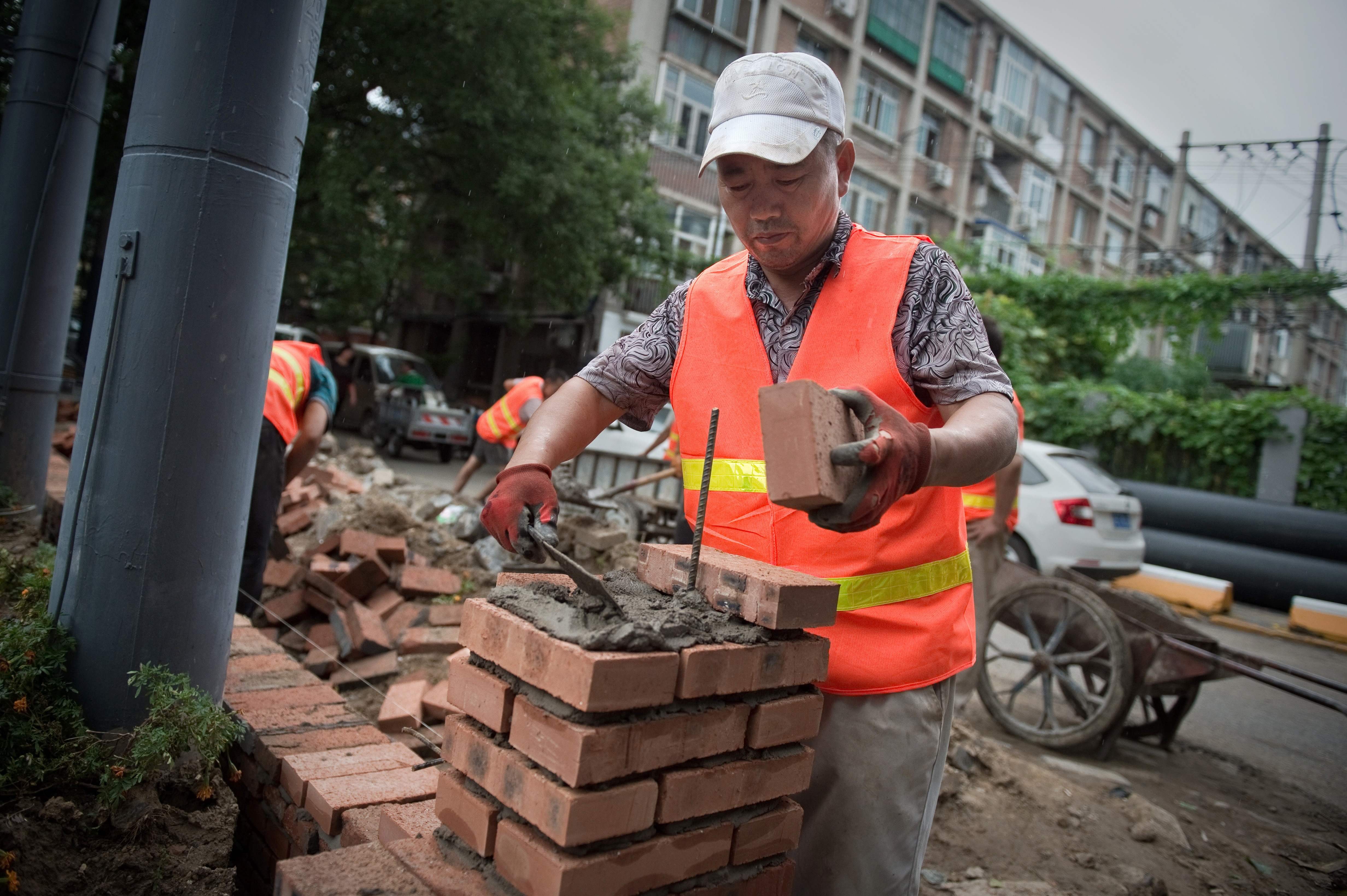 A construction worker builds a wall outside a compound in Beijing in August 2017. Photo: AFP