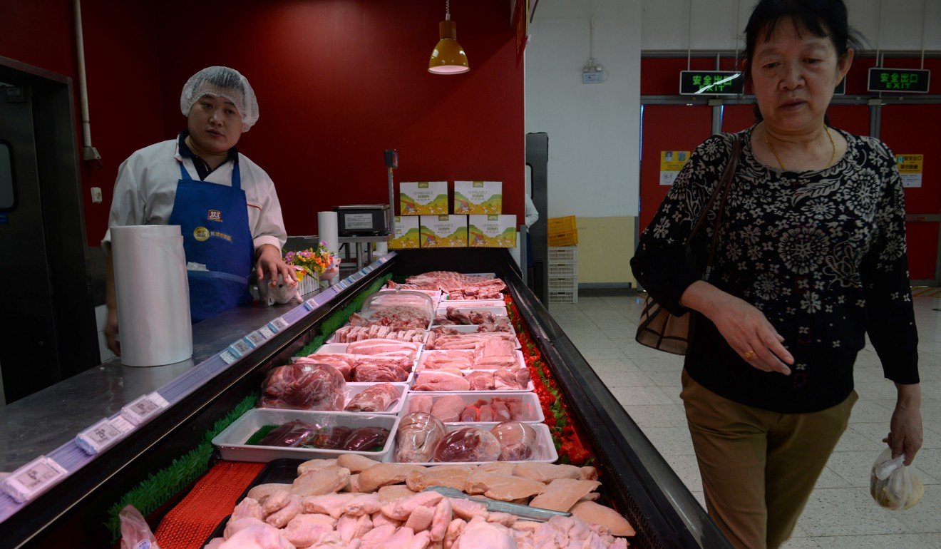 A woman looks at pork at a Walmart in Beijing on September 23. Photo: Reuters