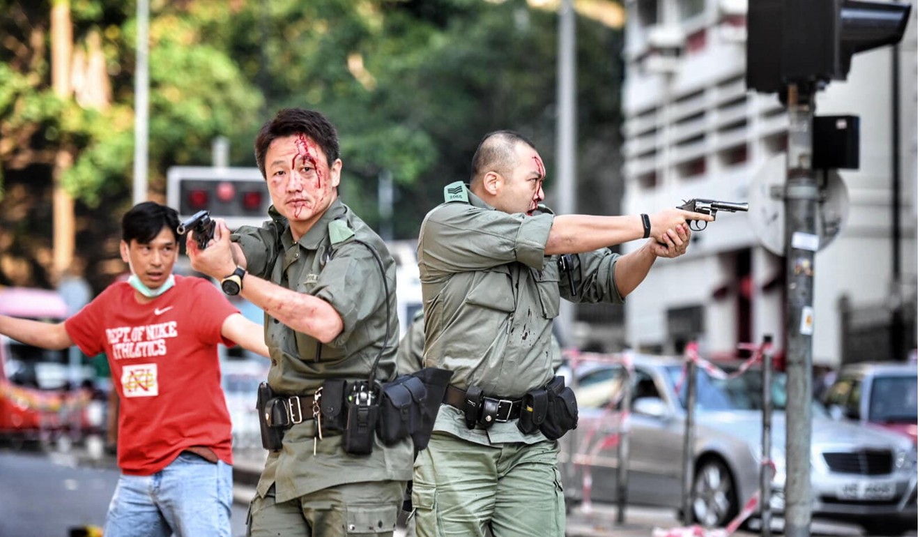 Two bloodied police officers raise their weapons. Photo: Rice Post