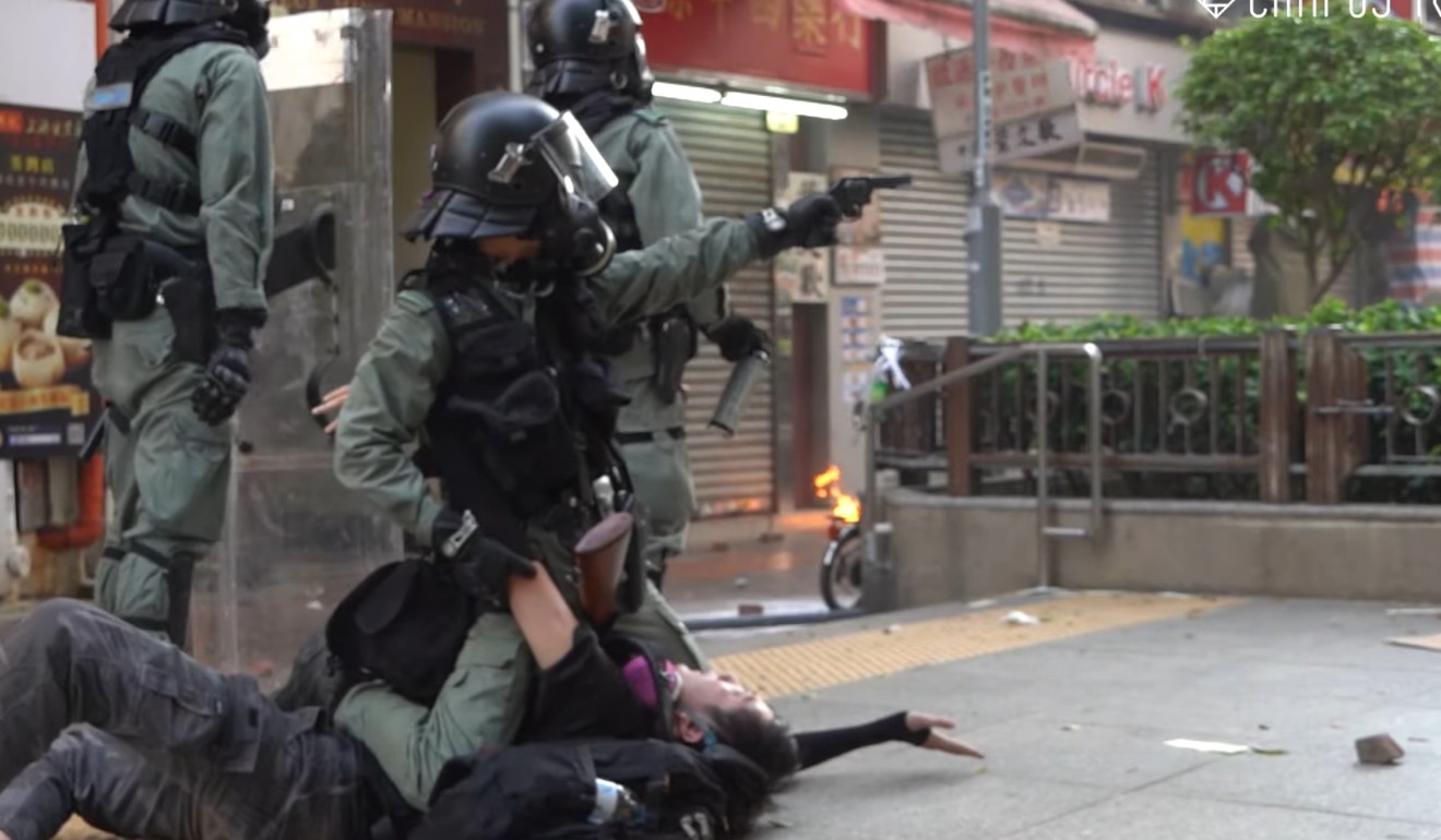 An officer points a gun in Tsuen Wan after subduing a protester. Photo: Campus TV, HKUSU
