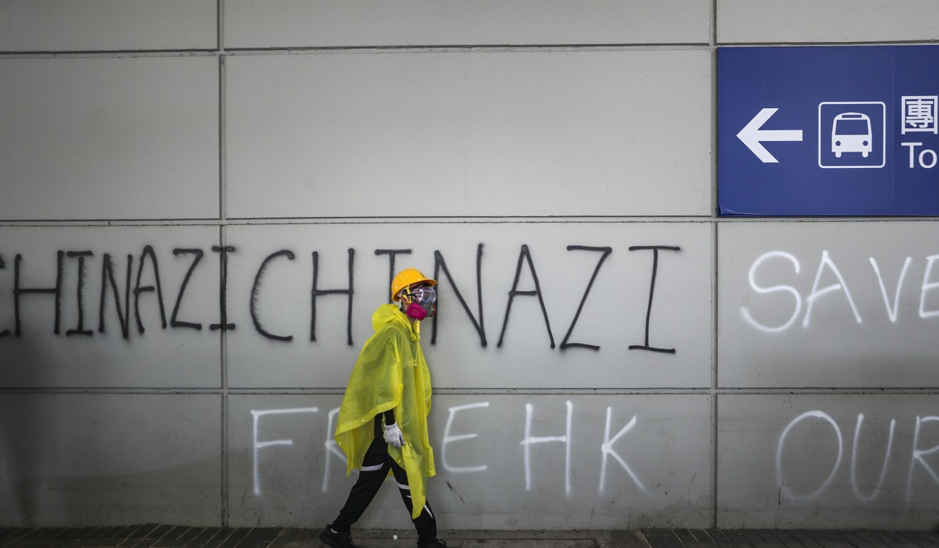 A protester walks past anti-China graffiti at Hong Kong International Airport on September 1. Photo: Sam Tsang