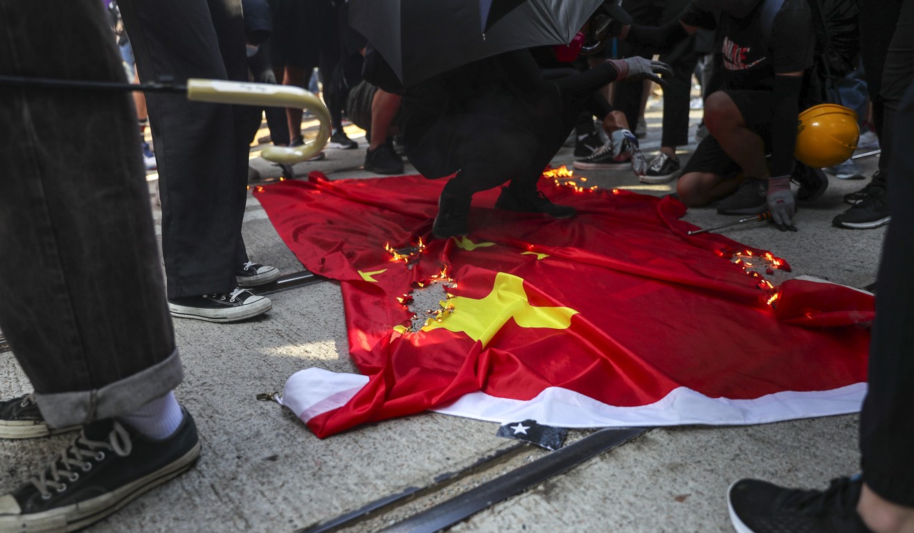 Protesters burn a Chinese national flag in Hong Kong on Tuesday, the 70th anniversary of the People’s Republic. Photo: Sam Tsang
