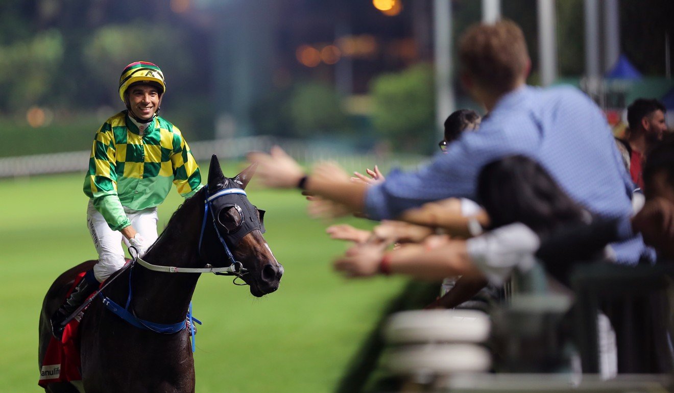 Joao Moreira high-fives the crowd after winning on Green Luck at Happy Valley.