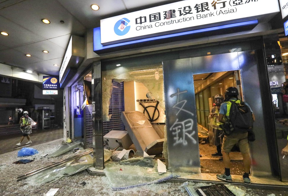 Anti-government protesters damage a China Construction Bank branch following a rally in defiance of the anti-mask law issued by the government on October 5, 2019. Photo: Felix Wong