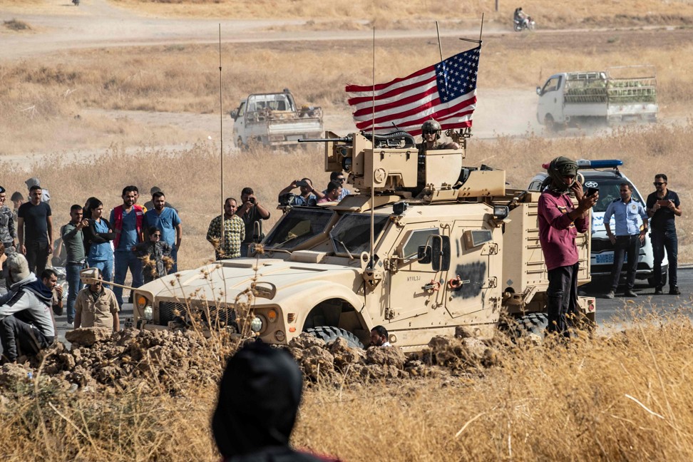 Syrian Kurds gather around a US armoured vehicle during a demonstration against Turkish threats on October 6, 2019. Photo: Agence France-Presse