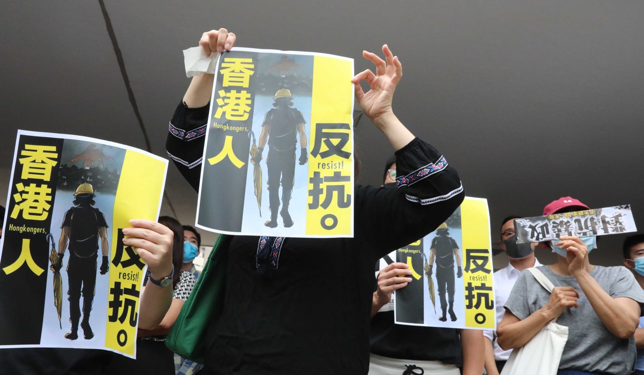 Protesters in the march hold up posters. Photo: Felix Wong
