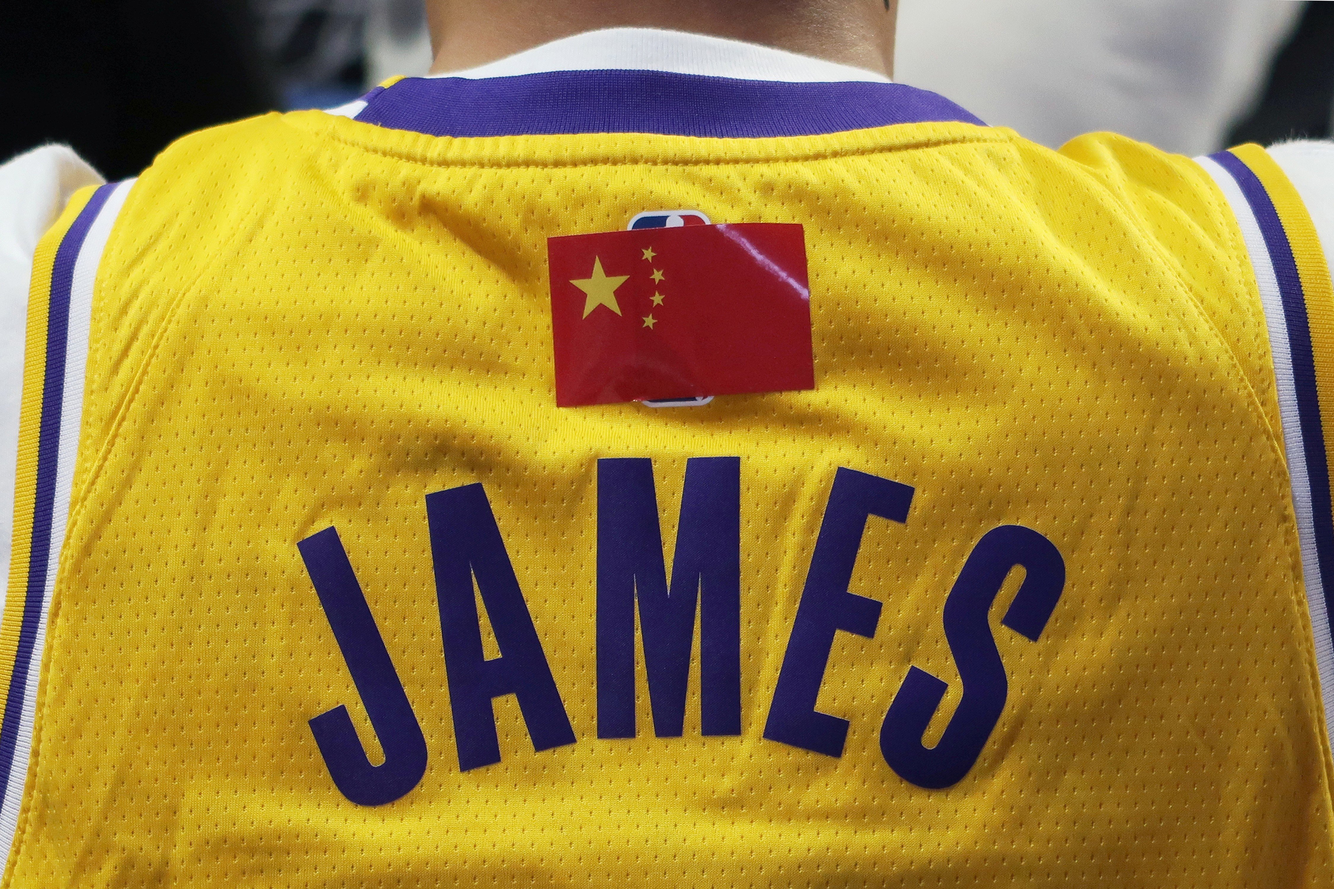 Following the anti-NBA fallout, a fan is seen wearing a LeBron James jersey with the NBA logo covered by a Chinese national flag, during a match between the Los Angeles Lakers and Brooklyn Nets at Shanghai’s Mercedes-Benz Arena, on Thursday, October 10. Photo: Reuters