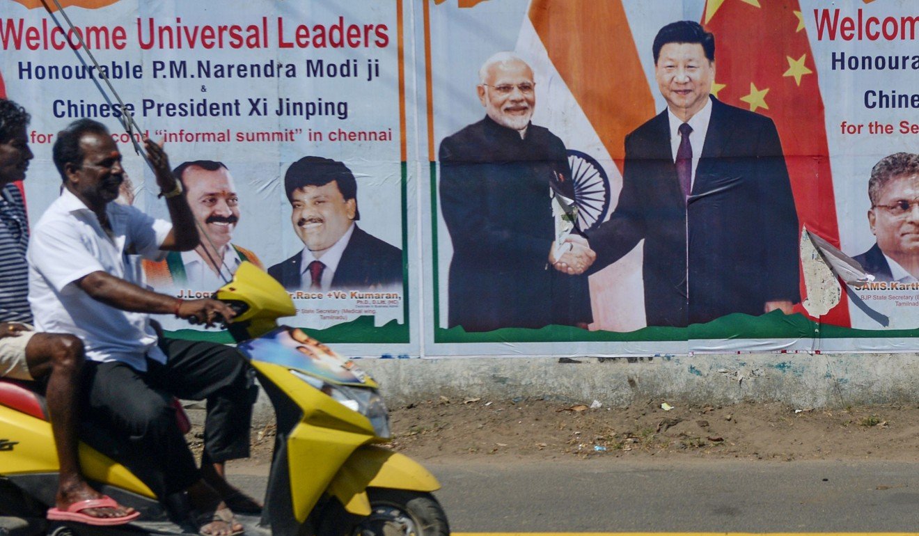 A motorist drives past a poster welcoming China’s President Xi Jinping in Chennai. Photo: AFP
